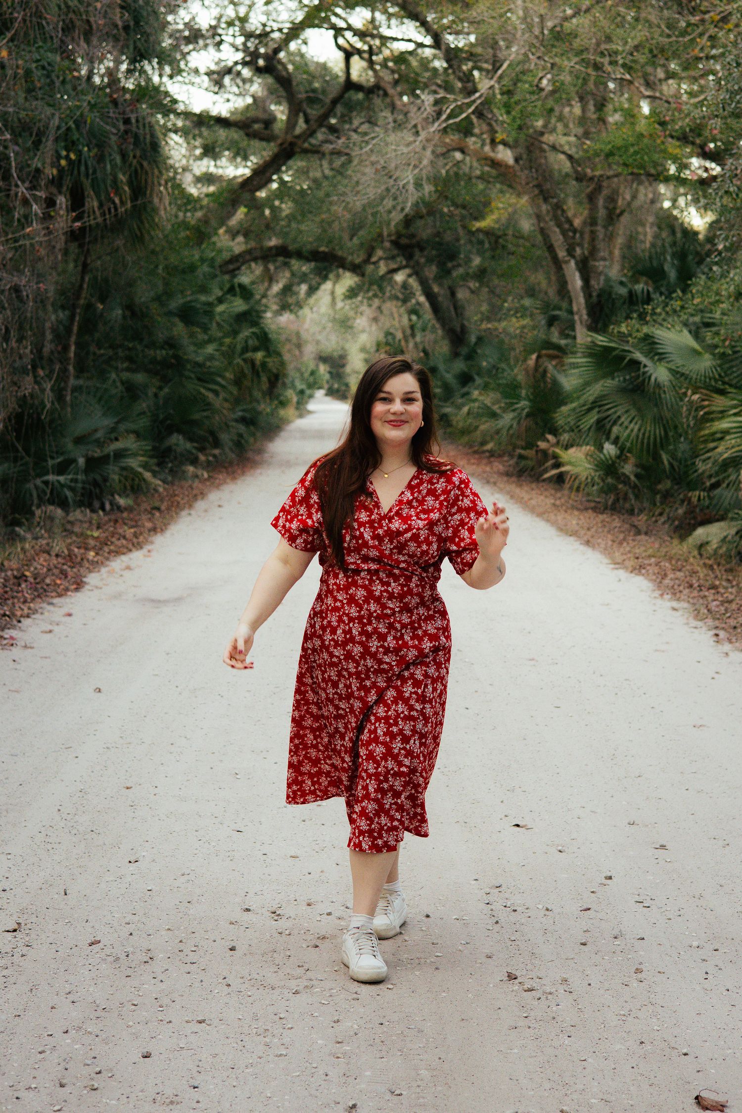Young woman in a red dress smiling in an outdoor setting in Florida