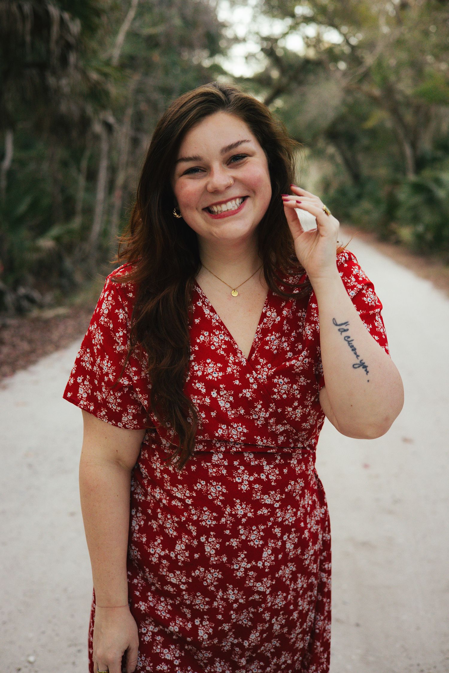 Young woman in a red dress smiling in an outdoor setting in Florida