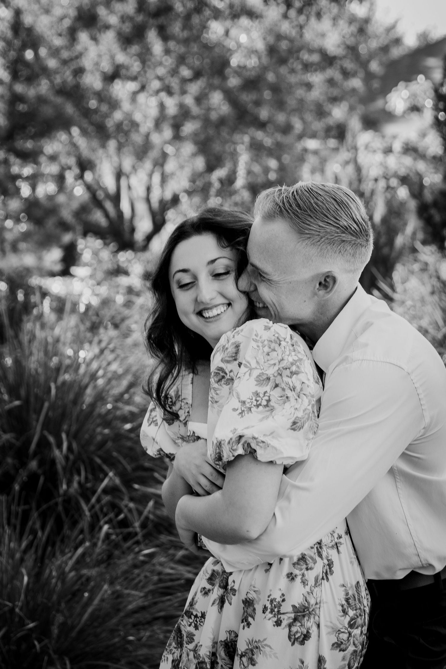 Young couple hugging in an outdoor setting in black and white