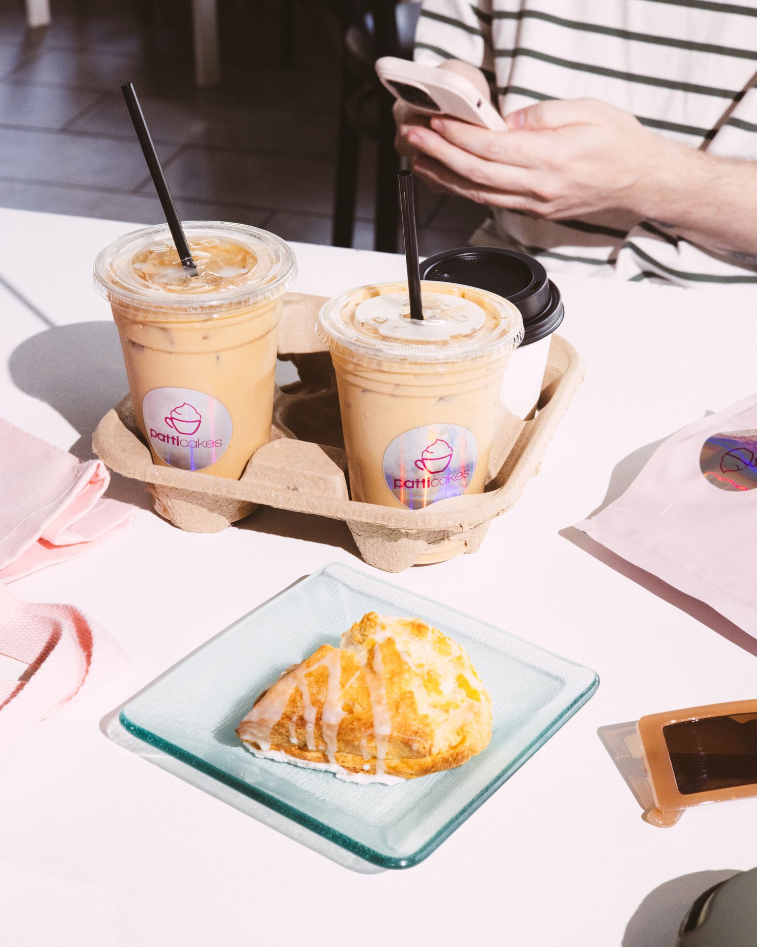 Coffee cups sitting on a table next to a scone