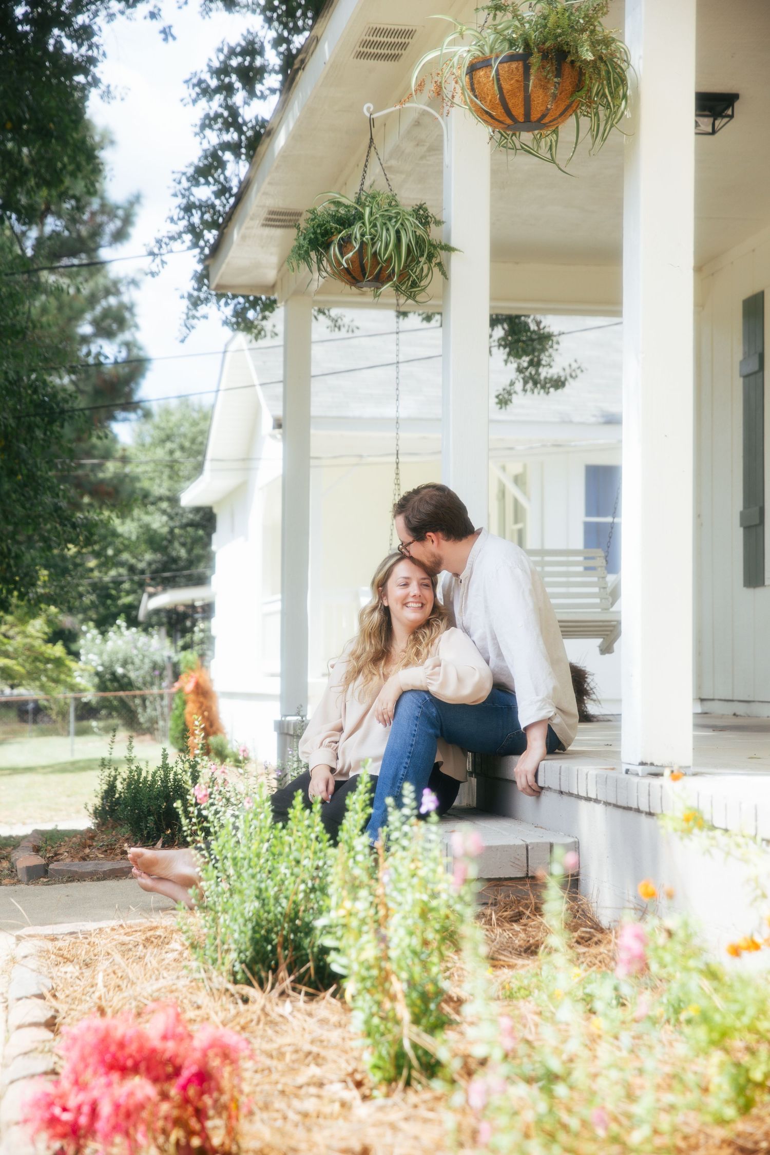 Young couple sitting together outside of a home smiling