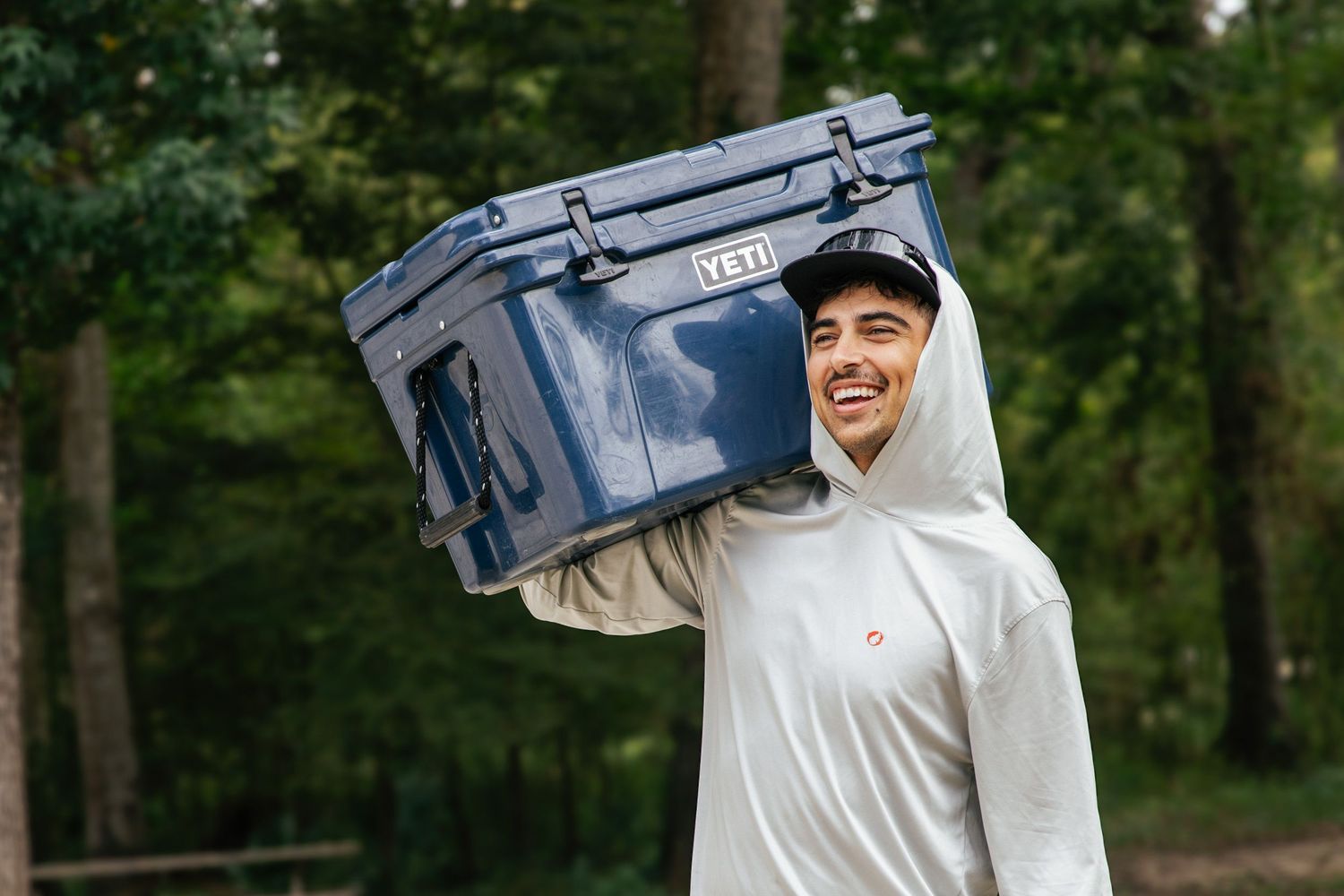 Young man carrying a yeti cooler