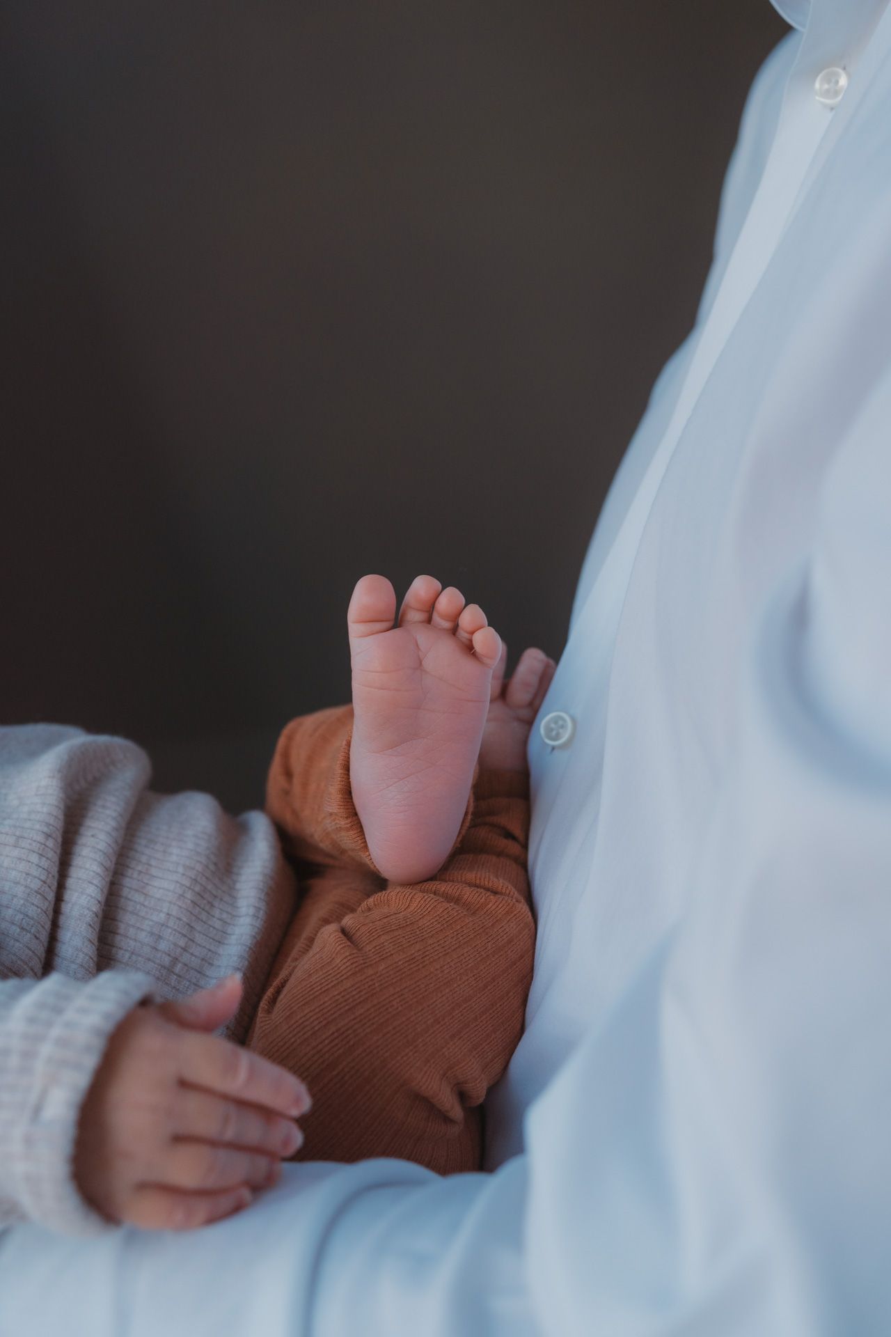 Voetjes van een pasgeboren baby tijdens een newbornshoot bij de ouders thuis.