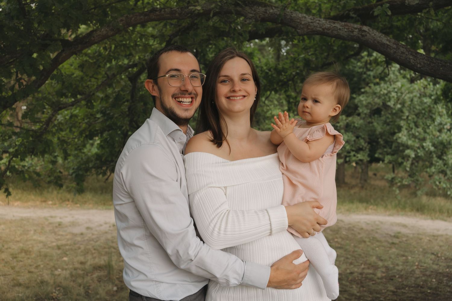 Mama, papa en dochter tijdens een zwangerschapsshoot in verwachting van hun tweede kindje.