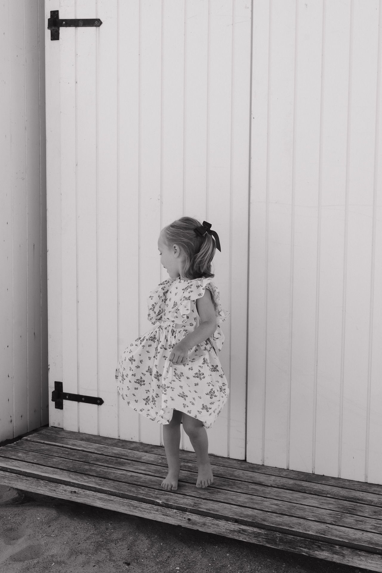 Meisje danst in haar jurkje aan zee tijdens een gezinsshoot.