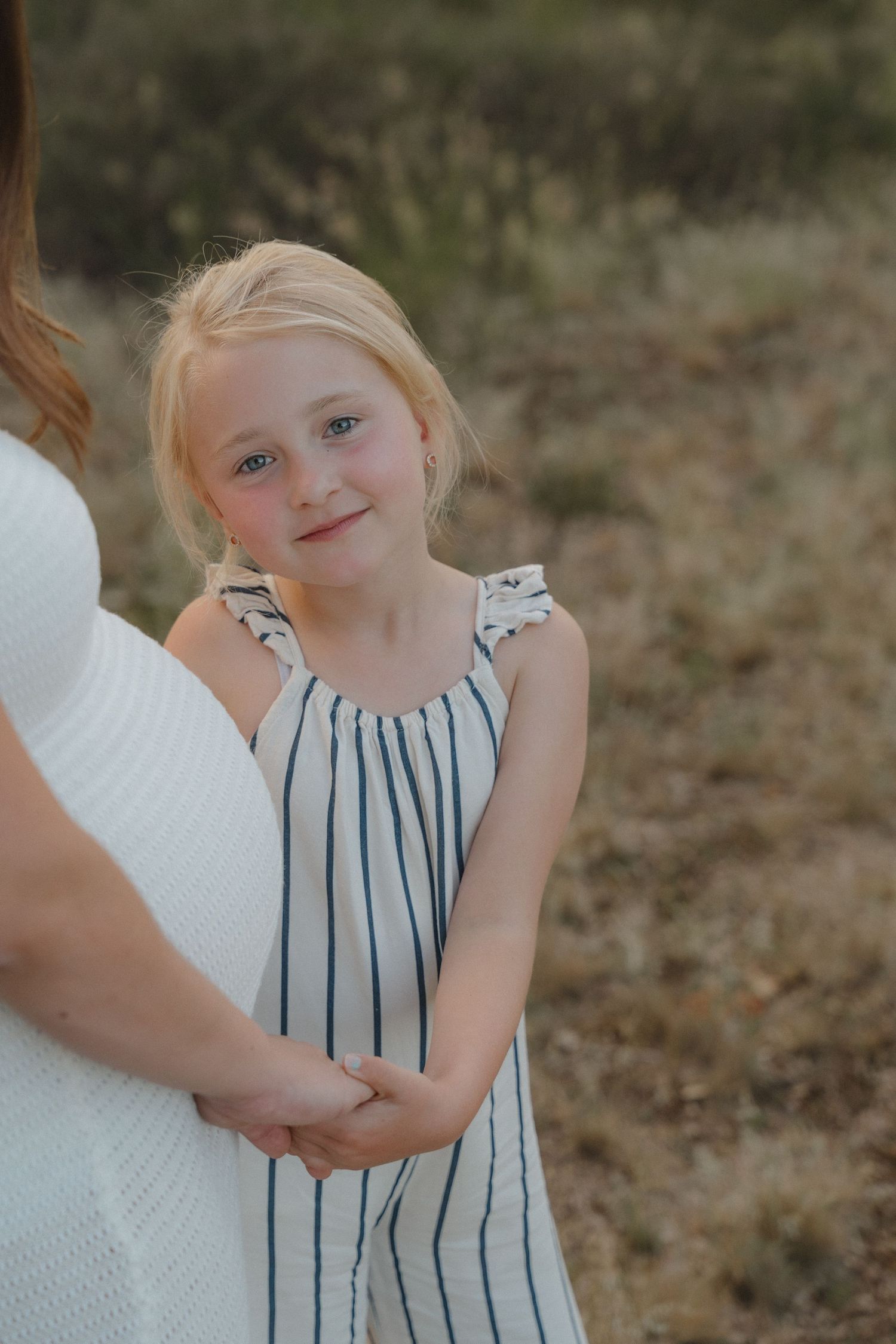 Dochter kijkt in de camera tijdens de zwangerschapsshoot van haar mama.