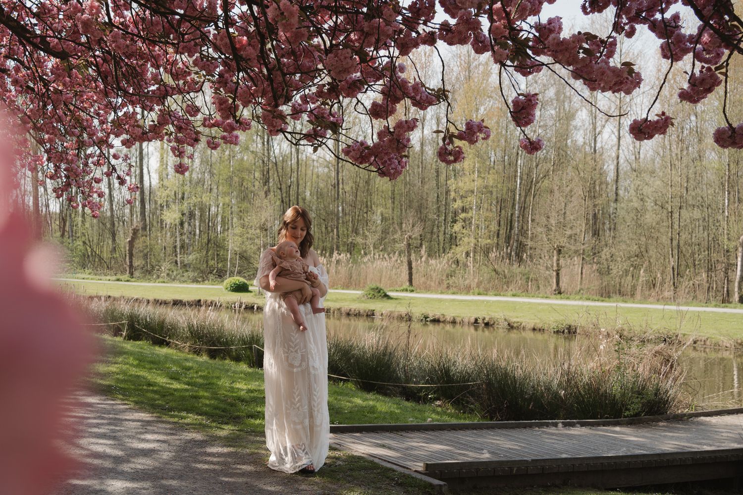 Mama en dochter samen tussen de bloesems tijdens een fotoshoot.