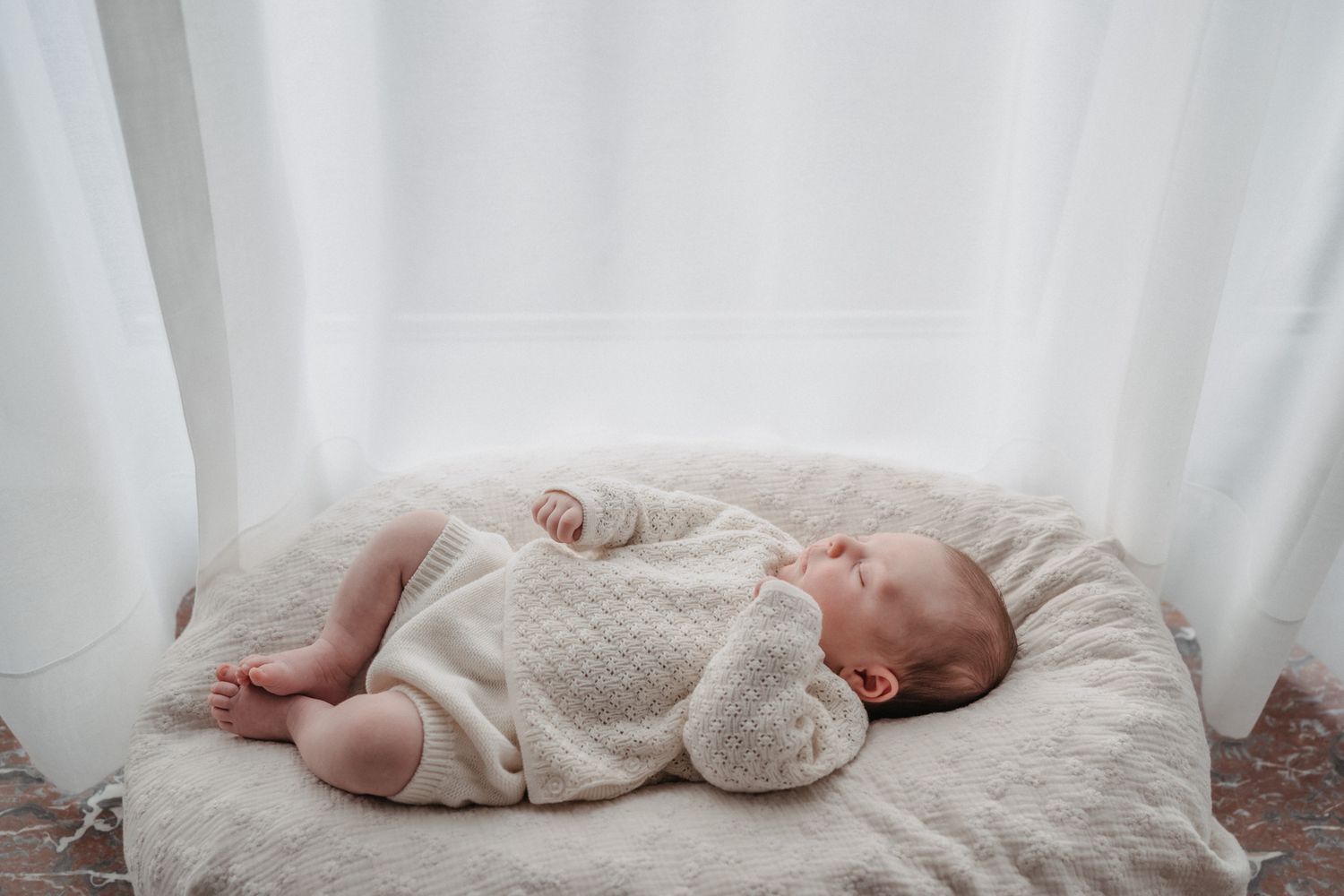 Pasgeboren baby thuis tijdens een newbornshoot.