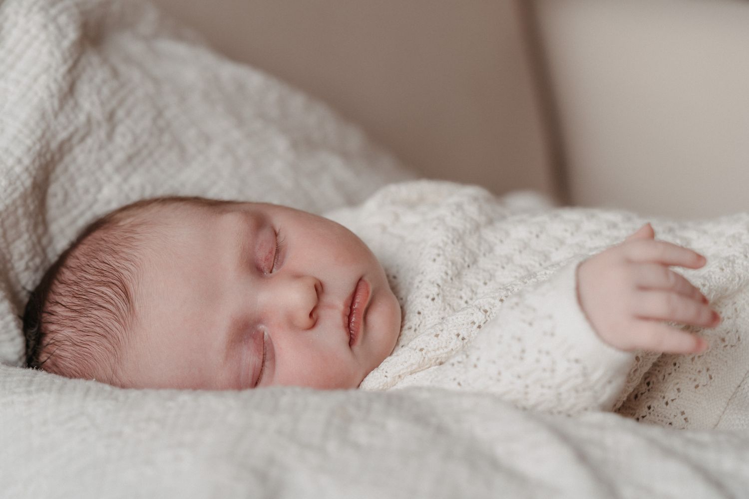 Pasgeboren baby thuis tijdens een newbornshoot.