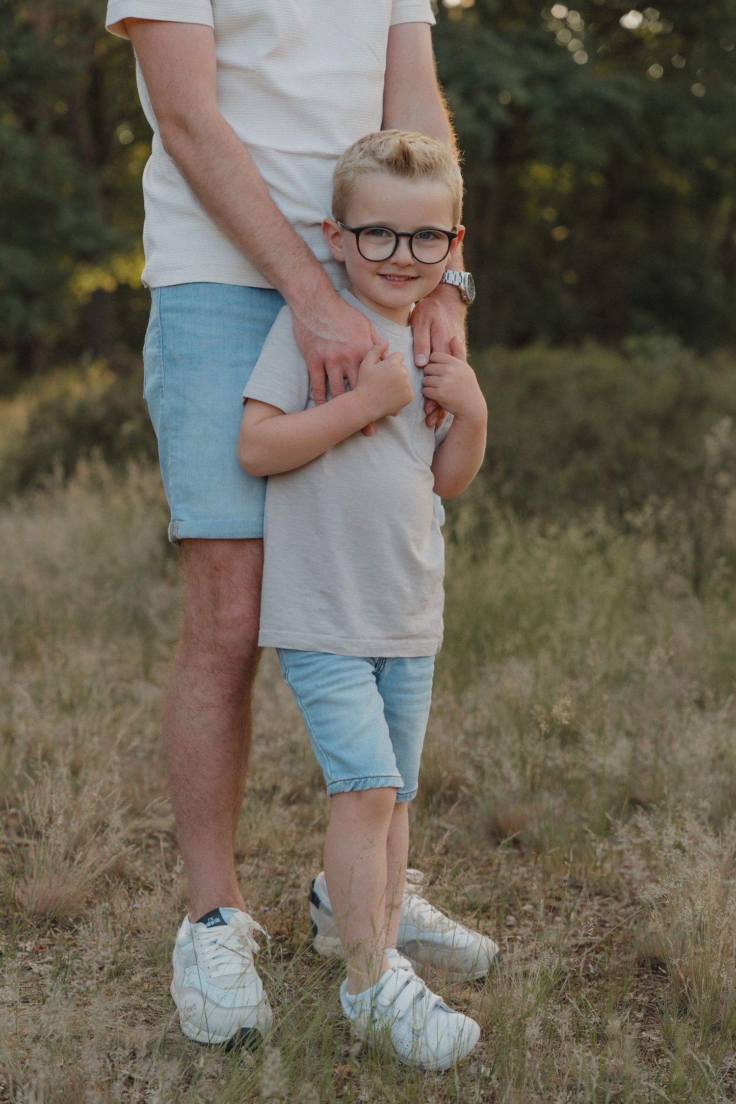 Zoon kijkt in de camera tijdens de zwangerschapsshoot van haar mama.