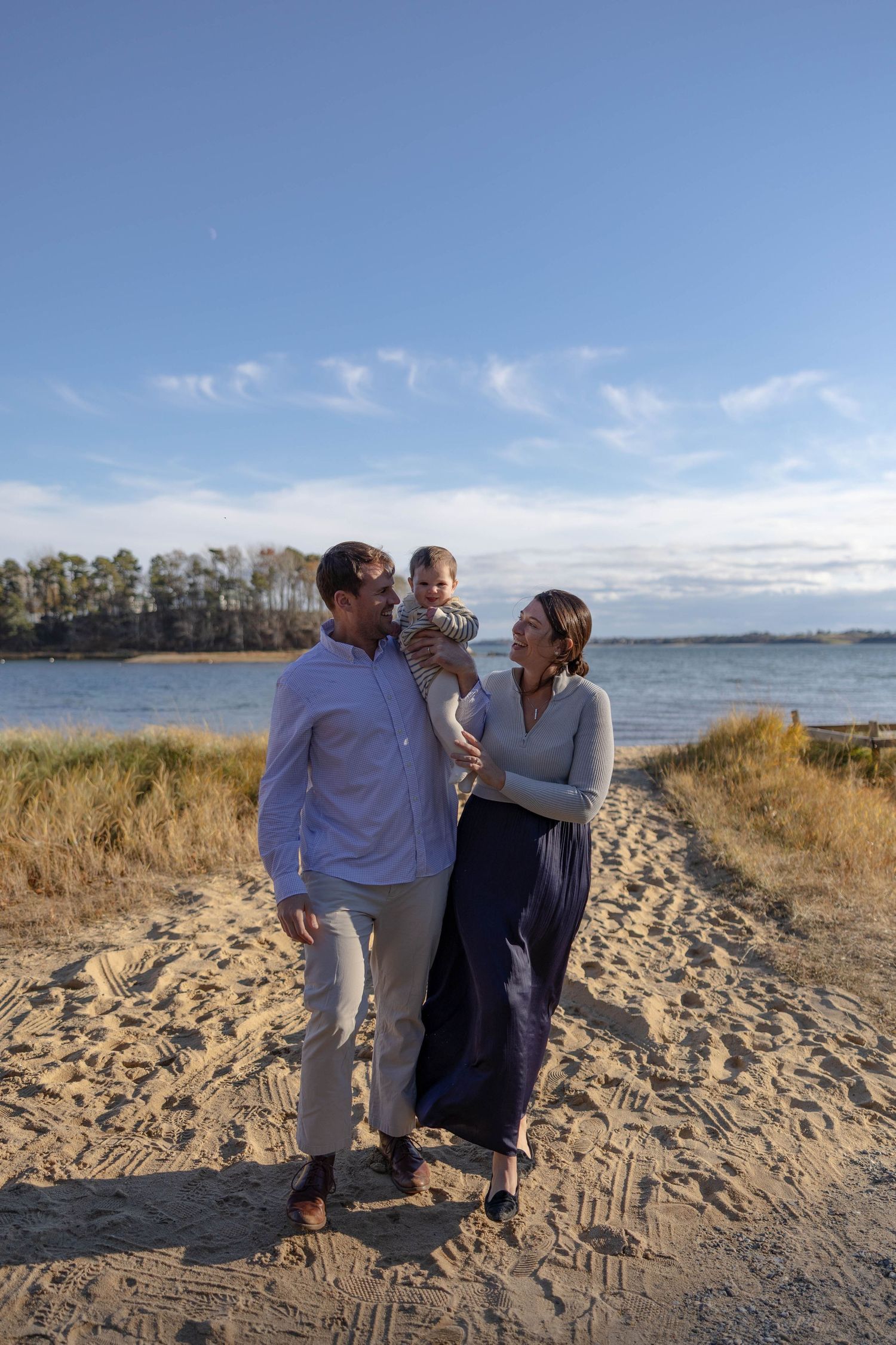 Family of 3 walk the beach in Cape Cod in this timeless New England fall photoshoot.