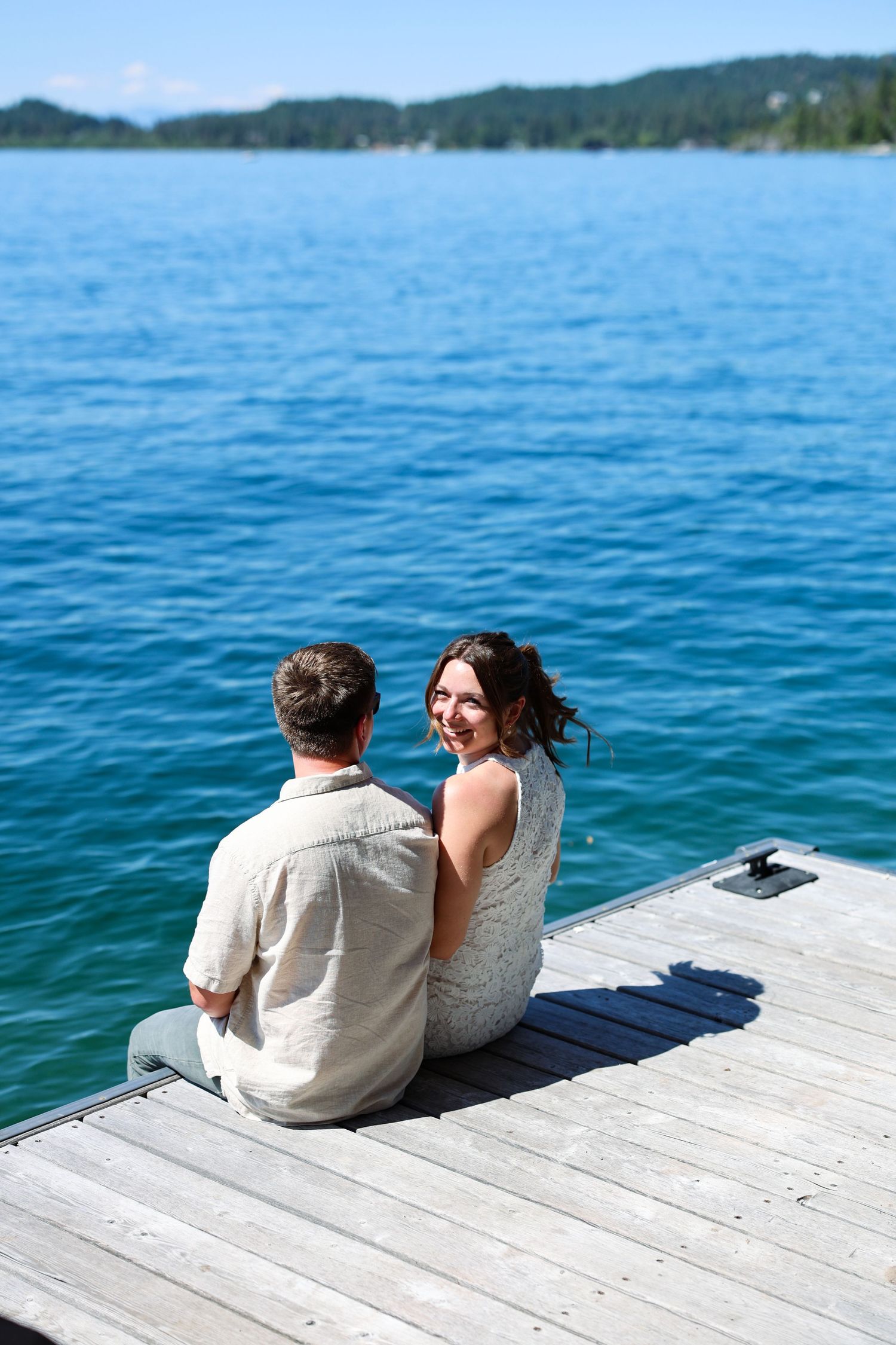 Engaged couple have a moment alone on the dock along Flathead Lake in Montana.