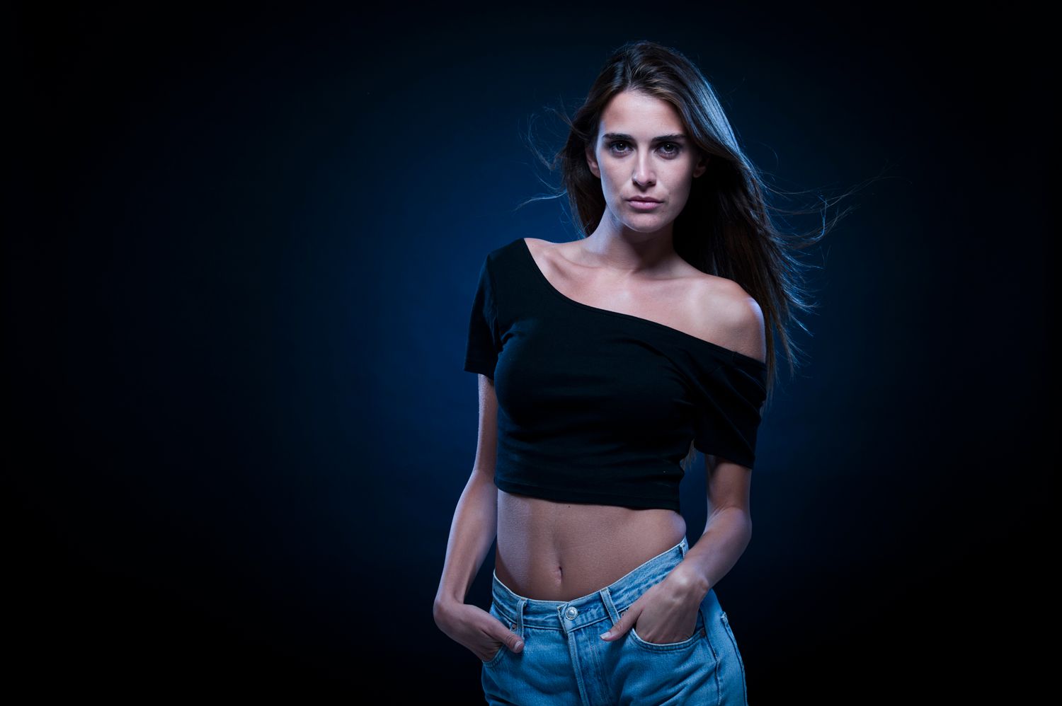 Fashion portrait with dramatic lighting showing bare shoulder and denim styling. Portrait Photographer in Ontario