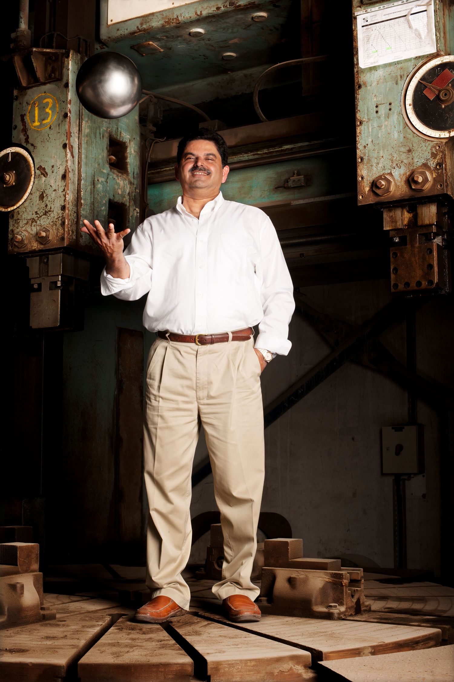 Person in white shirt and khaki pants posing in an industrial setting. Commercial and industrial Photographer in Guelph Ontario