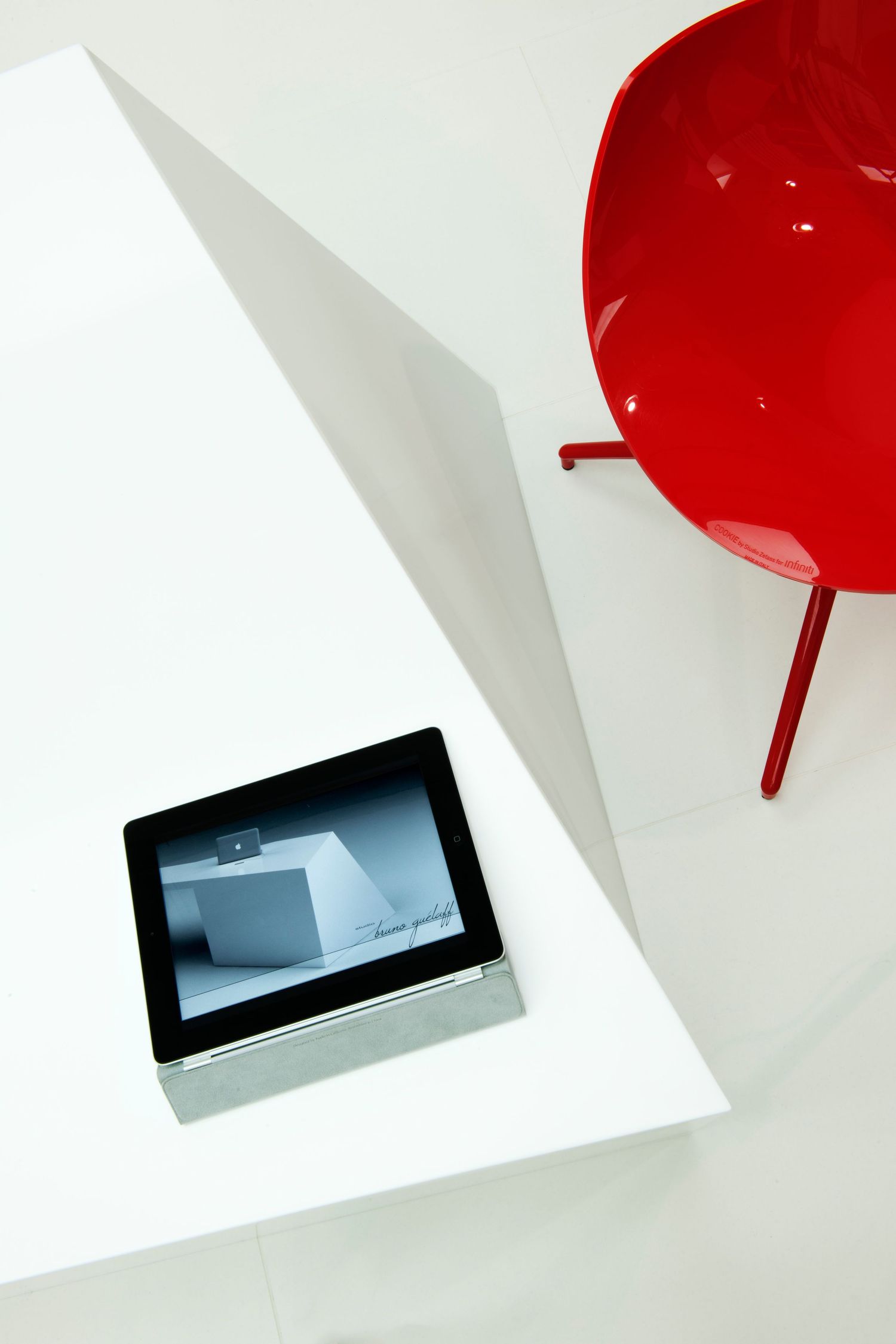 Minimalist design composition with red chair and electronic device on white background. commercial photographer in guelph