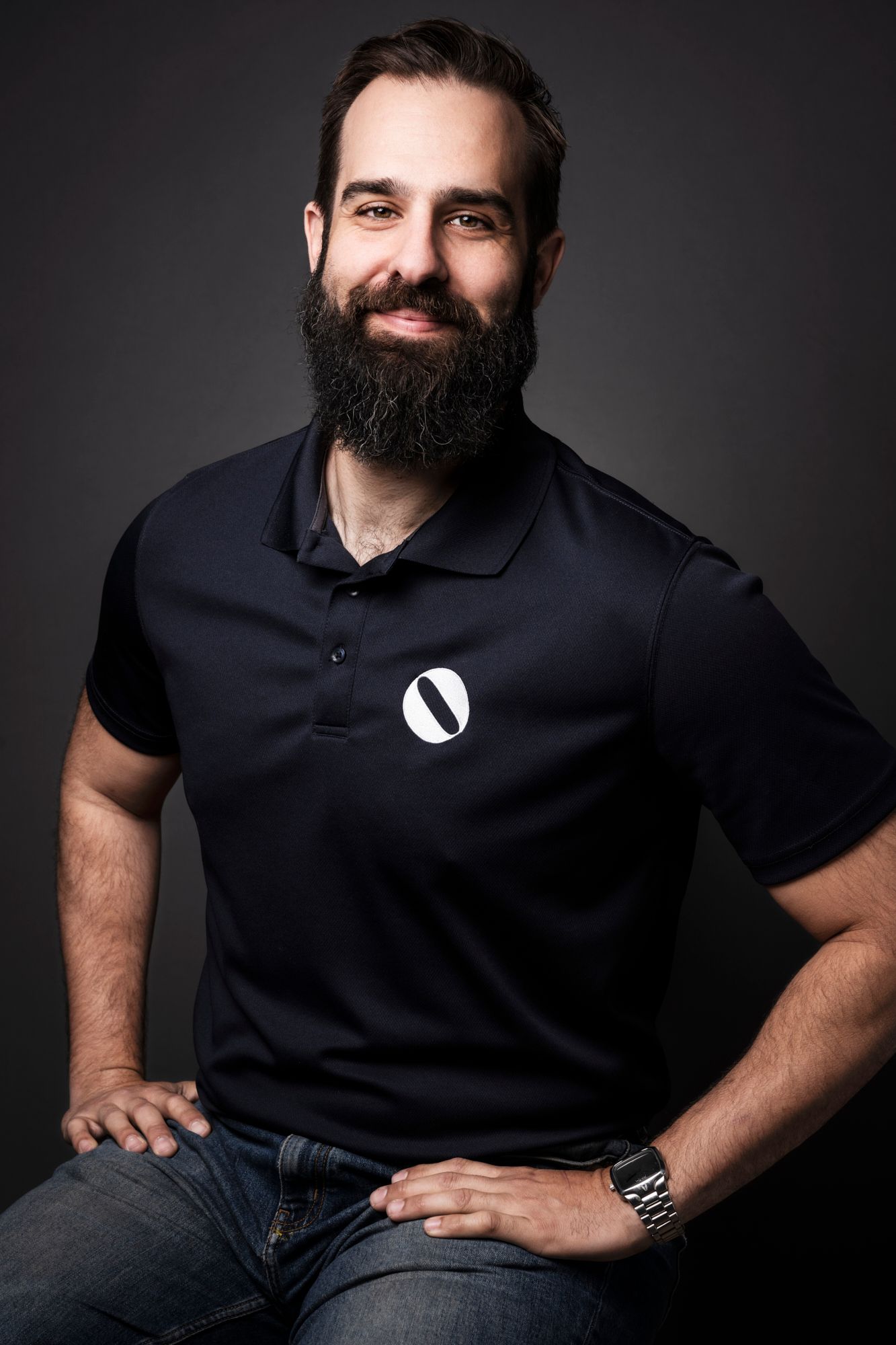 Professional portrait of person in dark polo shirt against gray background. Portrait Photographer in Ontario