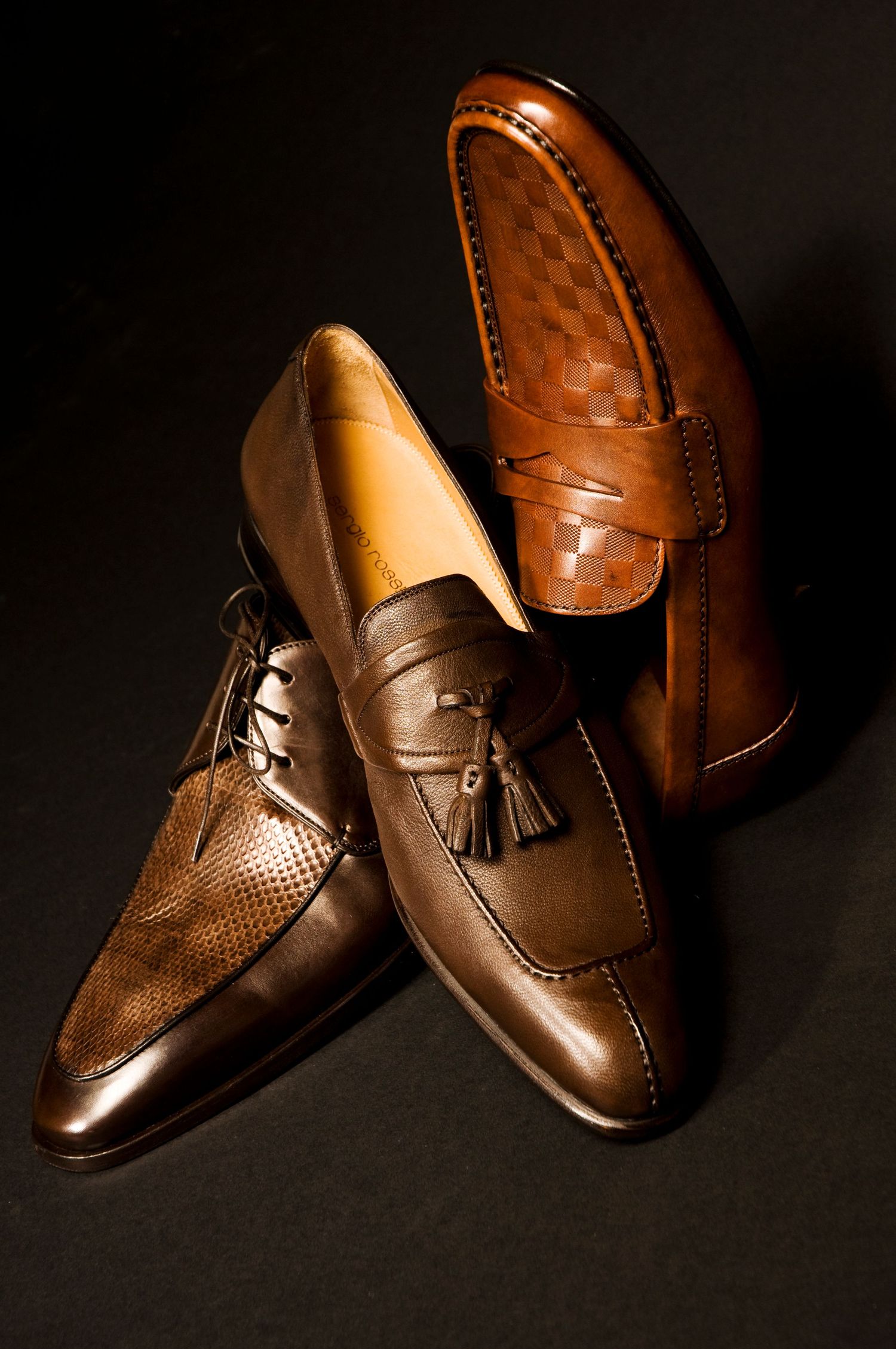 Classic brown leather loafers with tassels photographed in warm lighting against a dark background. Product Photography in Ontario