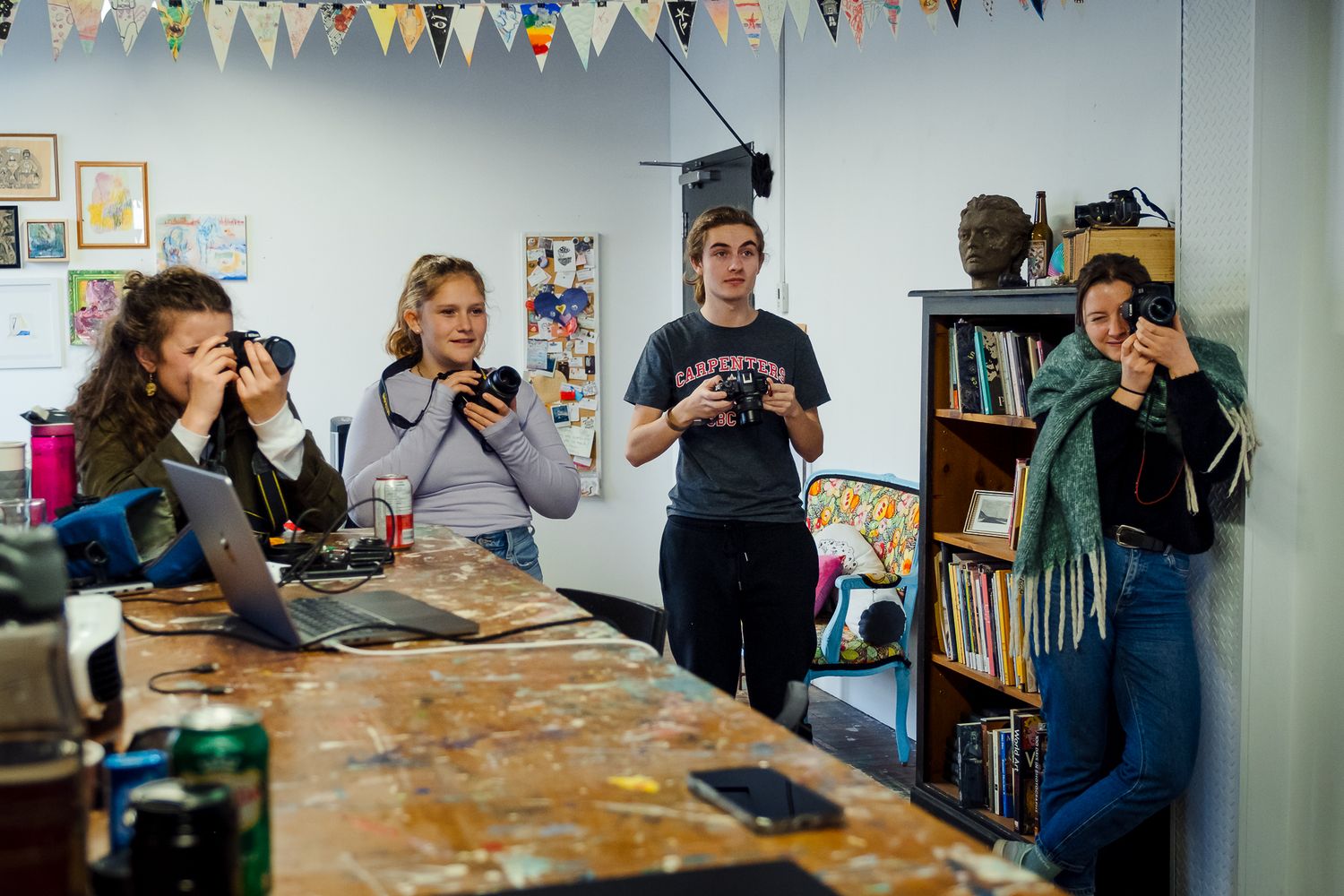 Photography classroom or workshop space with colorful banner decorations and people at tables. Photography workshops in guelph and ontario