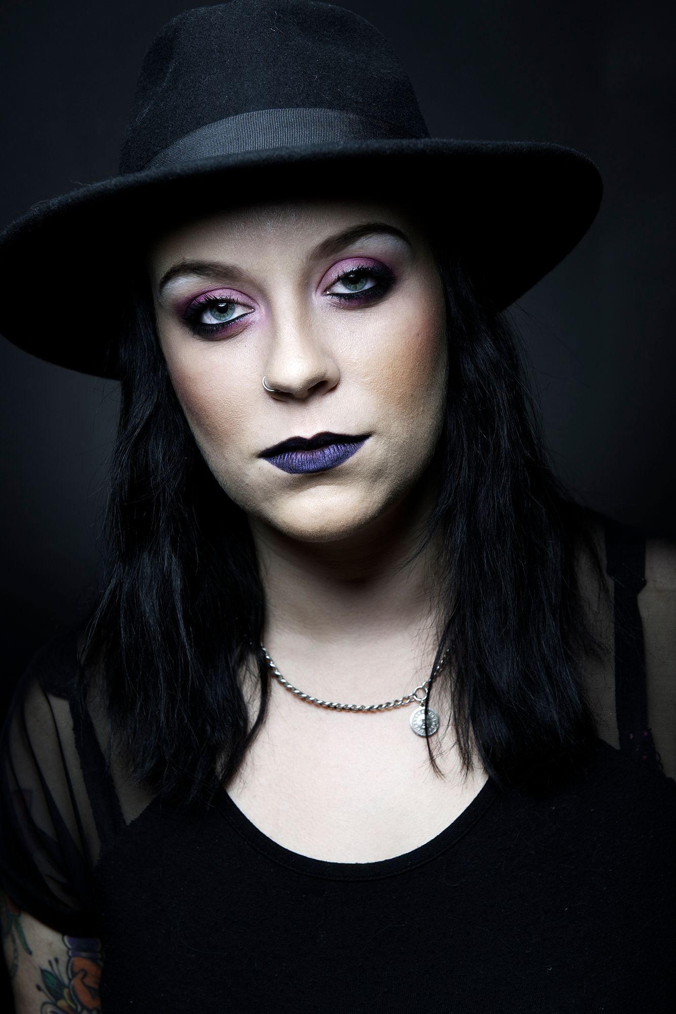 Dramatic portrait of person in black hat with purple lipstick and gothic makeup. Portrait Photographer in Ontario