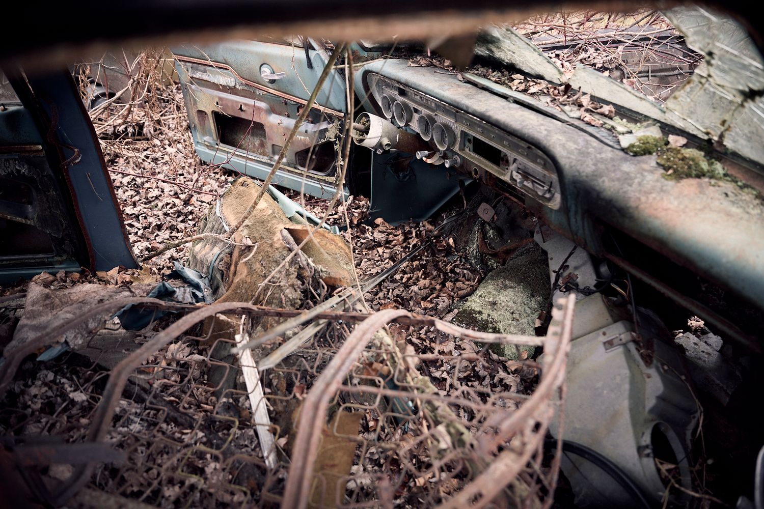 Close-up of deteriorating car parts with rust and debris in shadowy environment. Commercial Photographer in Guelph and surrounding areas