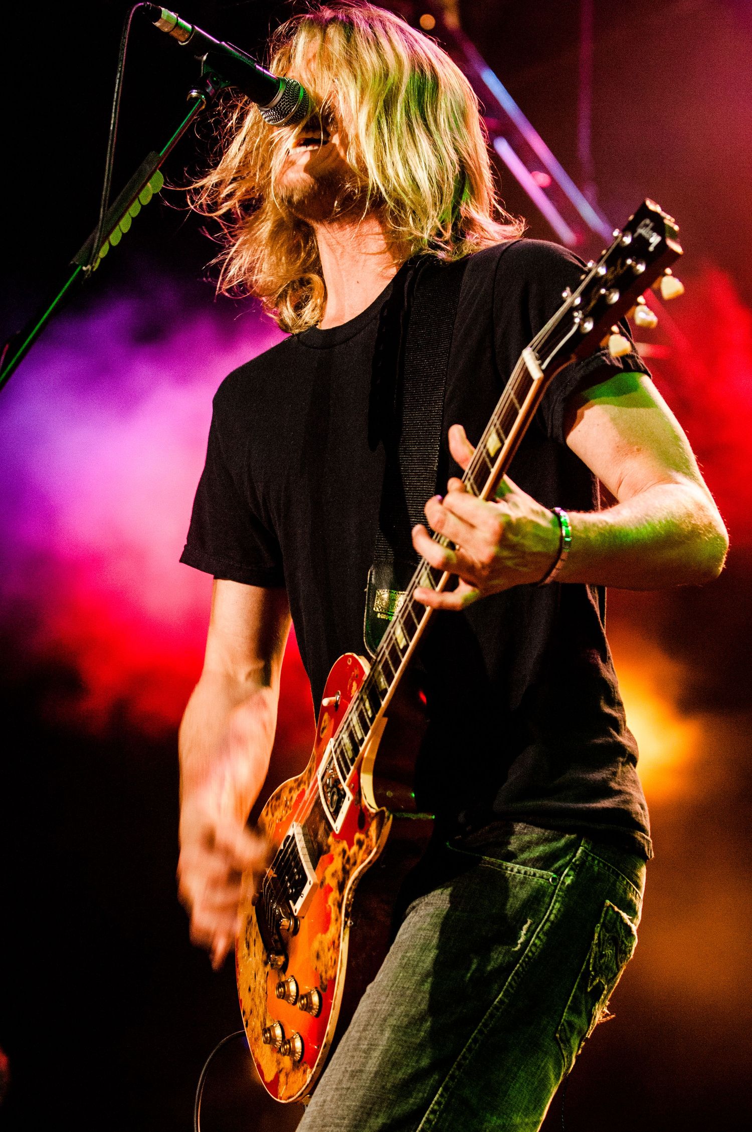 Guitarist playing Les Paul guitar on stage with colorful concert lighting effects.Event photographer in Ontario Canada