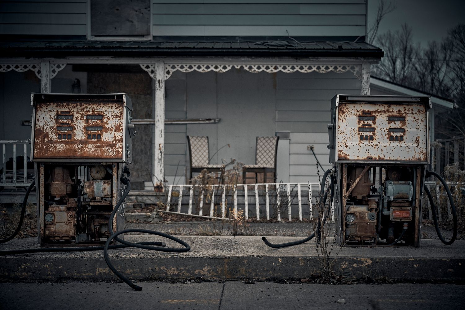Two antique gas pumps outside an old rural storefront. Commercial Photographer in Guelph and surrounding areas