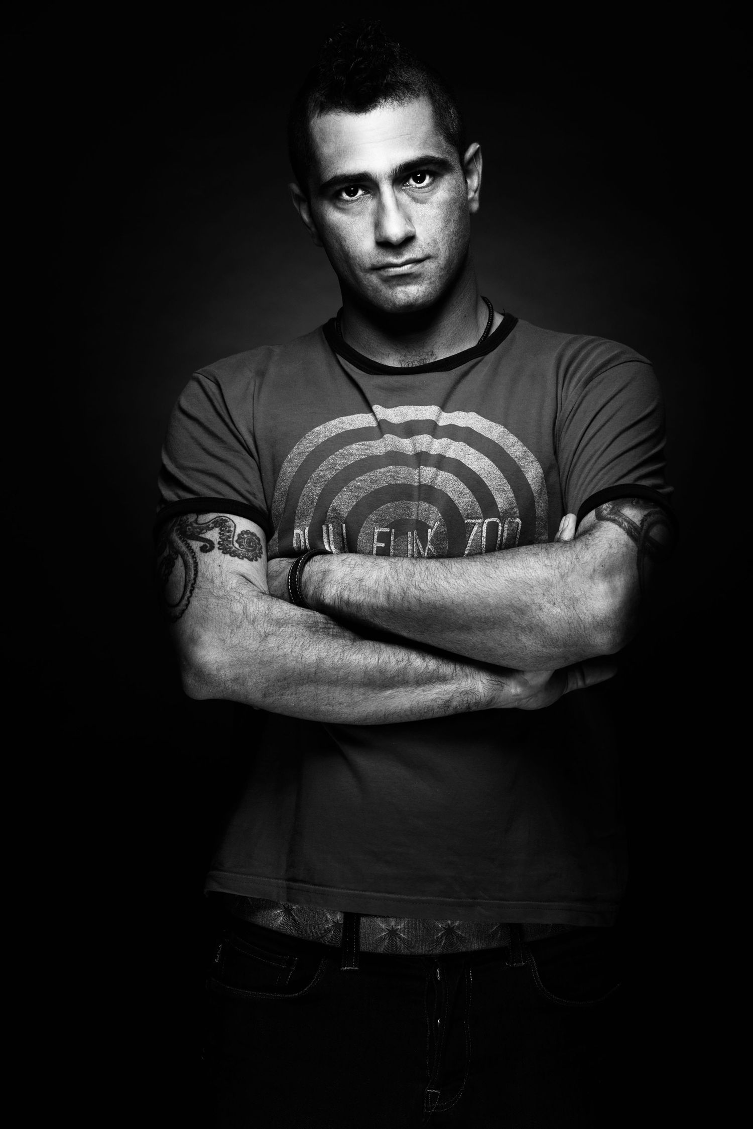 Moody black and white portraits of a man with tattoos in casual attire. Portrait Photographer in Ontario