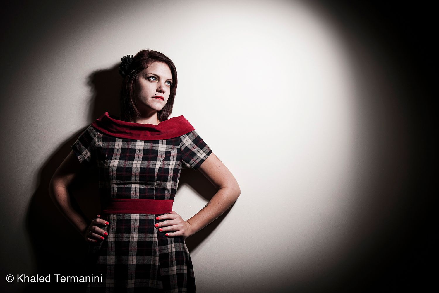 Dramatic portrait series in plaid dress against spotlit background. .Portrait Photographer in Guelph Ontario