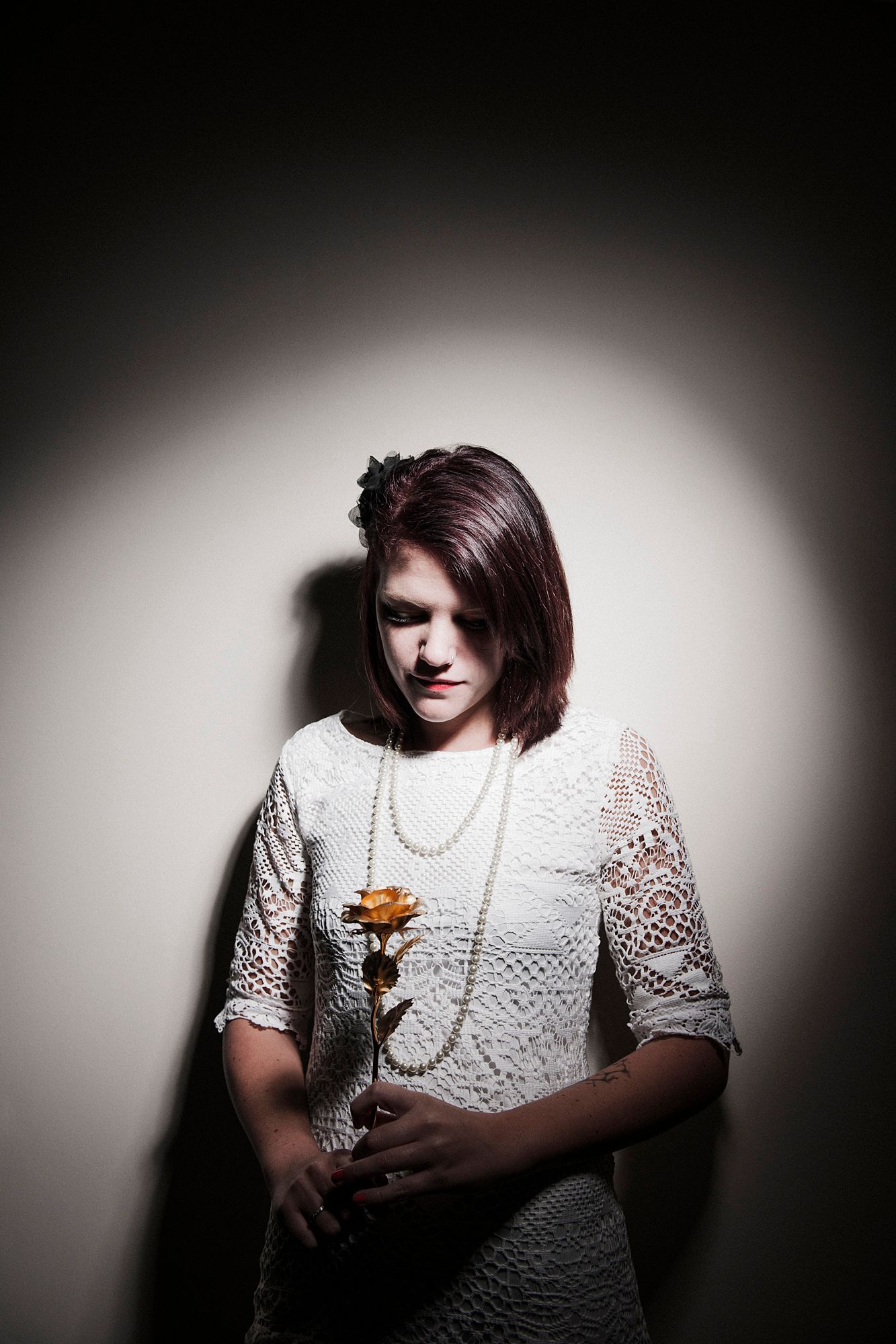 Dramatic black and white portrait series showing a person in white lace against dark background.