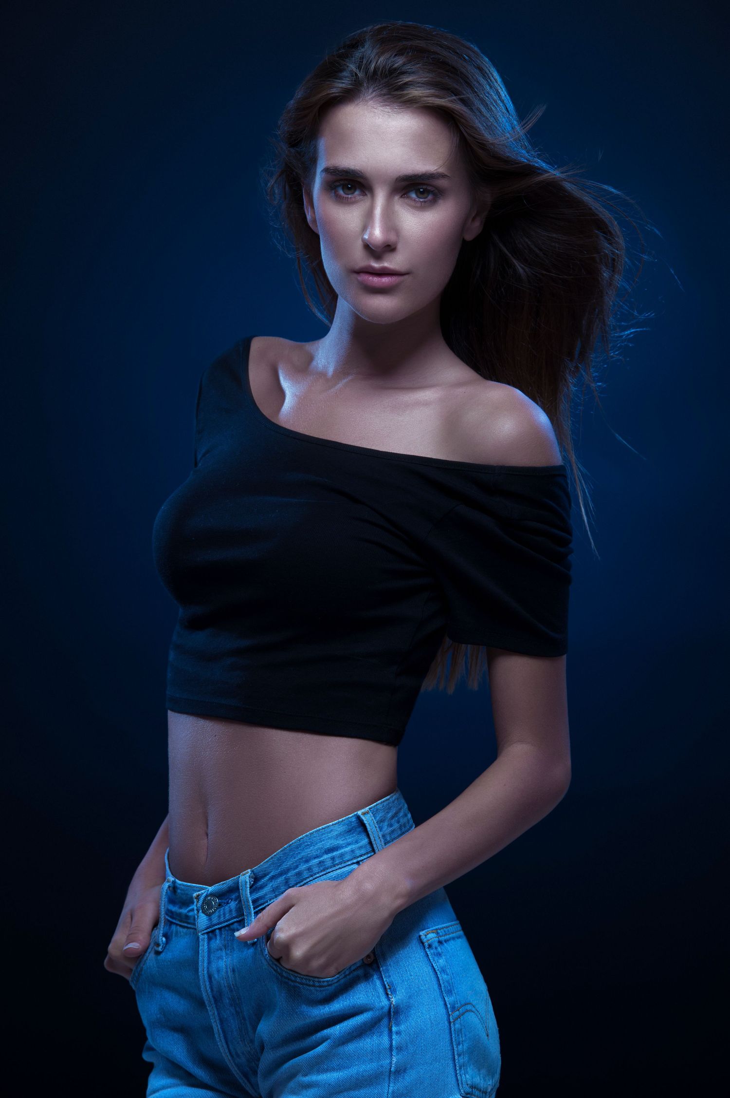 Fashion photo series with model in black top and jeans against dark blue background. portrait photographer in guelph and surrounding areas