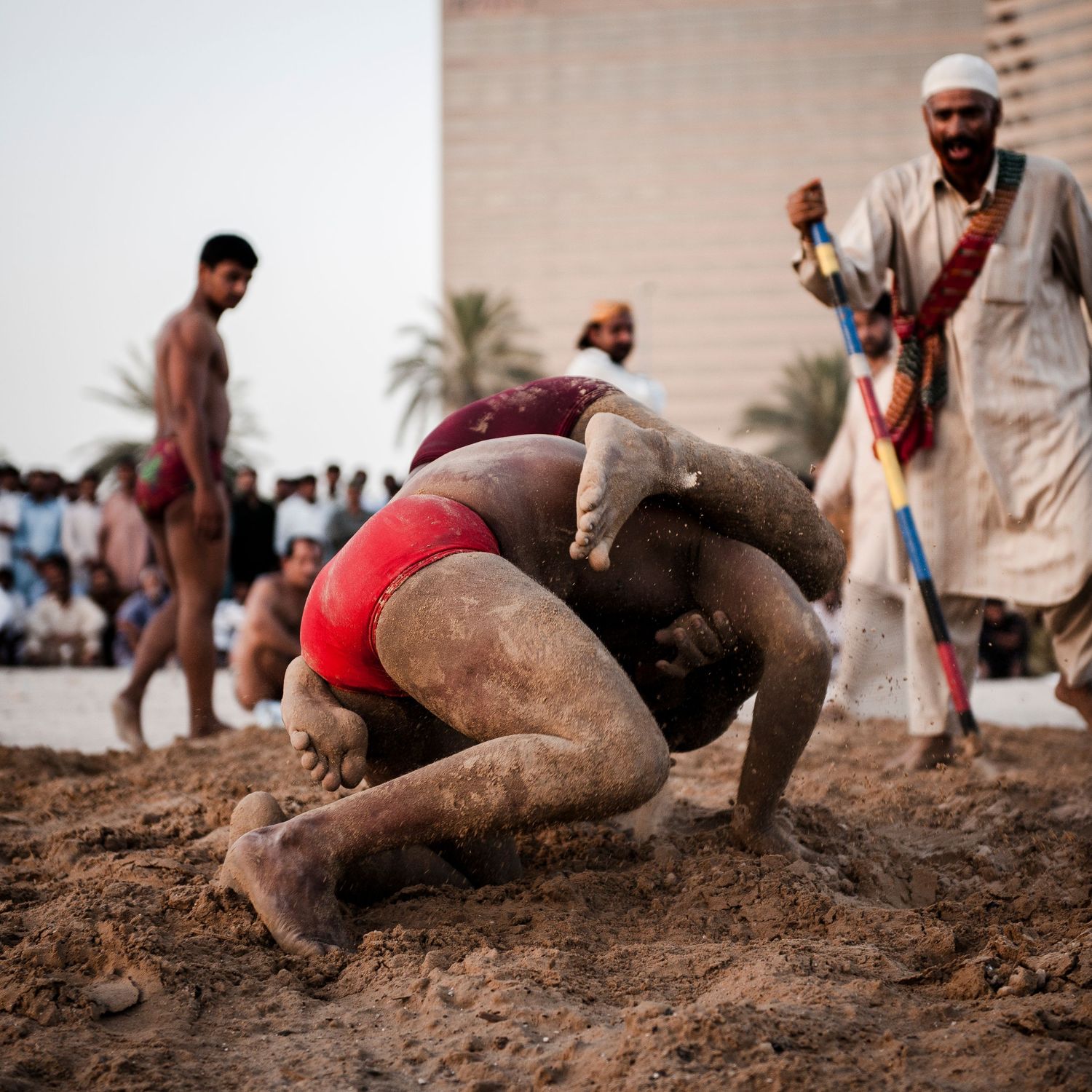 Athletes competing in a muddy wrestling or sports competition in an outdoor setting. Commercial Photographer in Guelph and surrounding areas