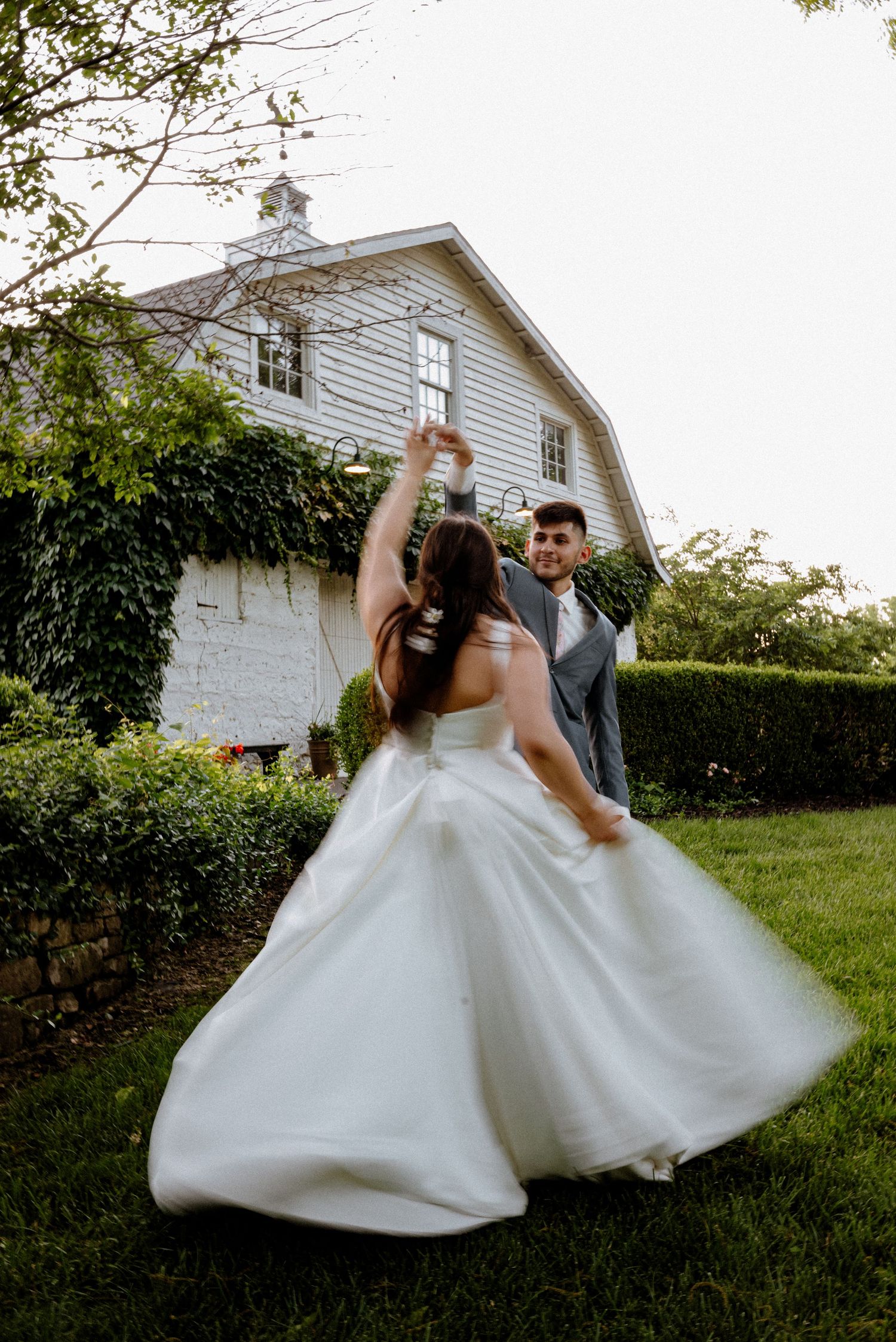 Bride and groom spinning to show the brides dress flowing. The photo is taken outside at their wedding venue Hasletine Estate