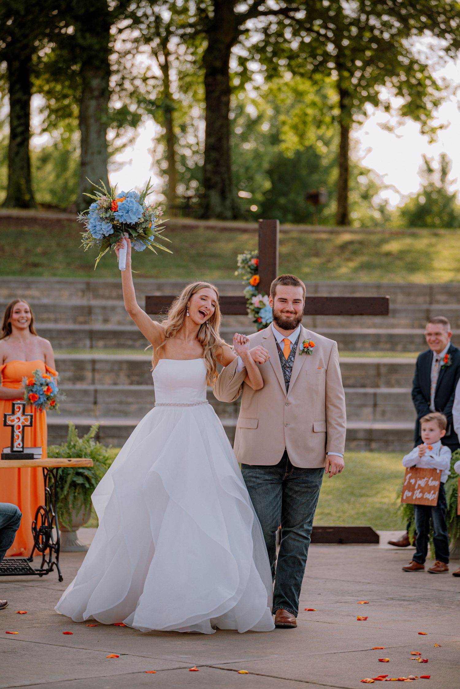 Bride and groom are happy as the walk down the aisle, surrounded by friends and family.