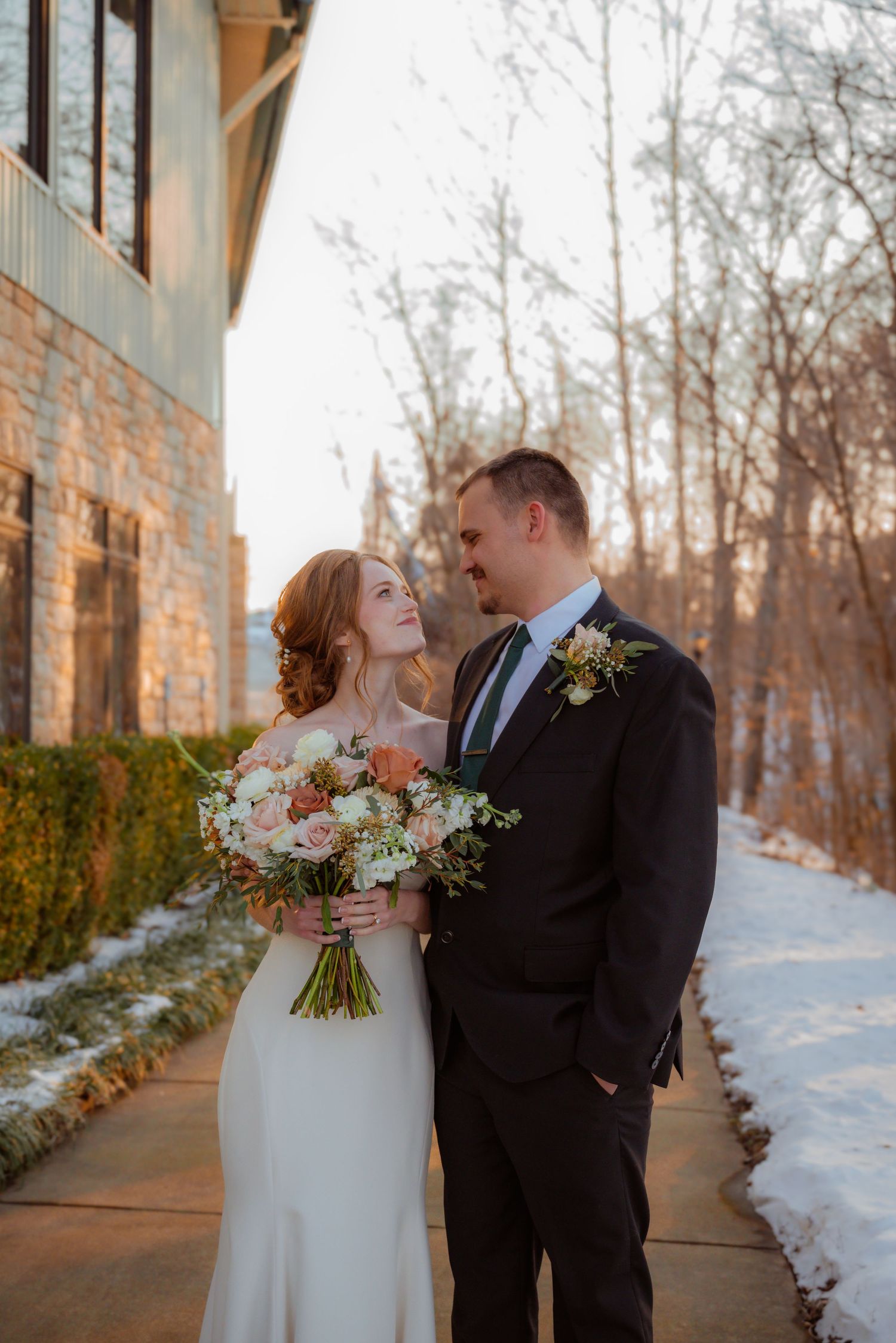 Bride and groom standing posing for a bridal portrait on a beautiful plantation, surrounded by snow.