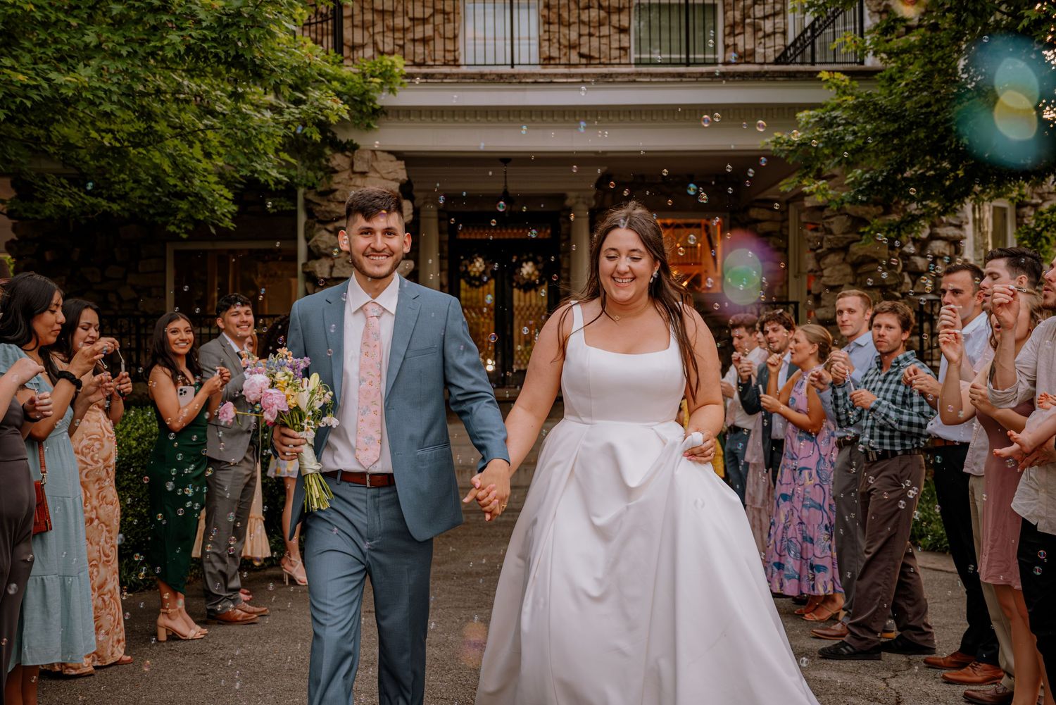 Bride and groom getting ready for the big send off at the front of Haseltine Estate, surrounded by happy friends and family
