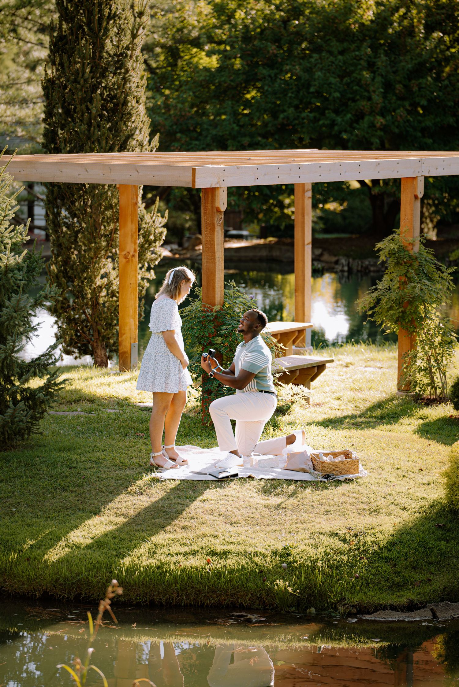 Couple happy as he asks to marry her while on a island in a garden