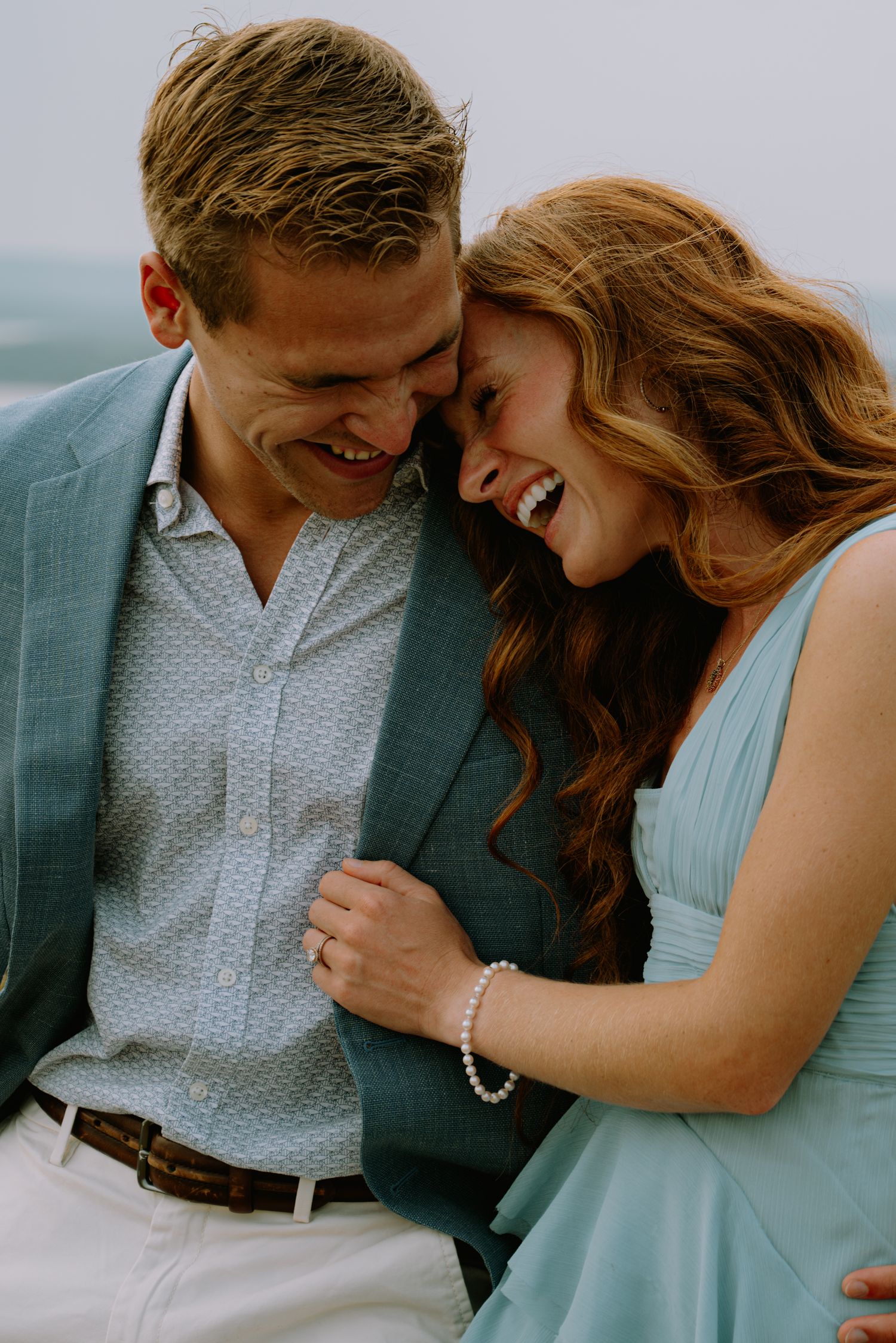 Couple laughing while holding onto each other