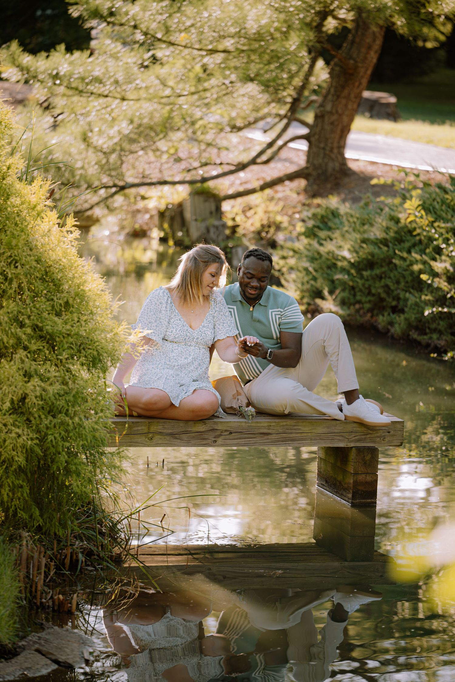 Couple embracing while sitting on a small dock over the water