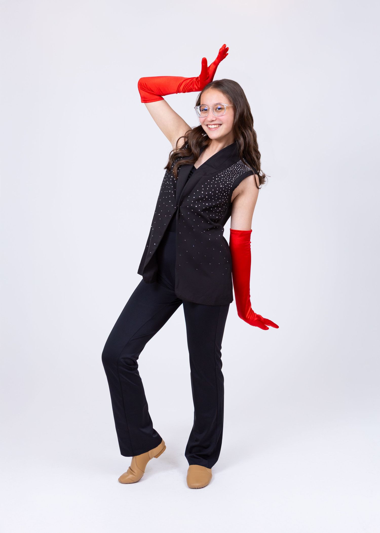 Teen dancer in black sparkle vest and red elbow gloves strikes a dramatic jazz pose.