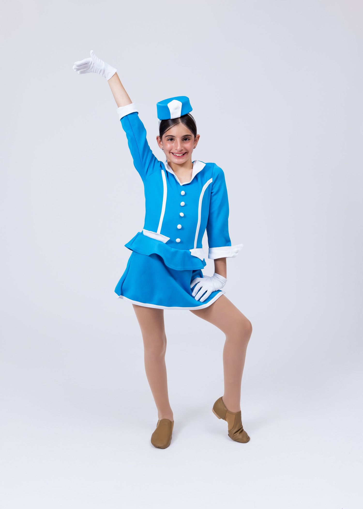 Young girl in blue and white marching band costume with hat and gloves strikes a dance pose.
