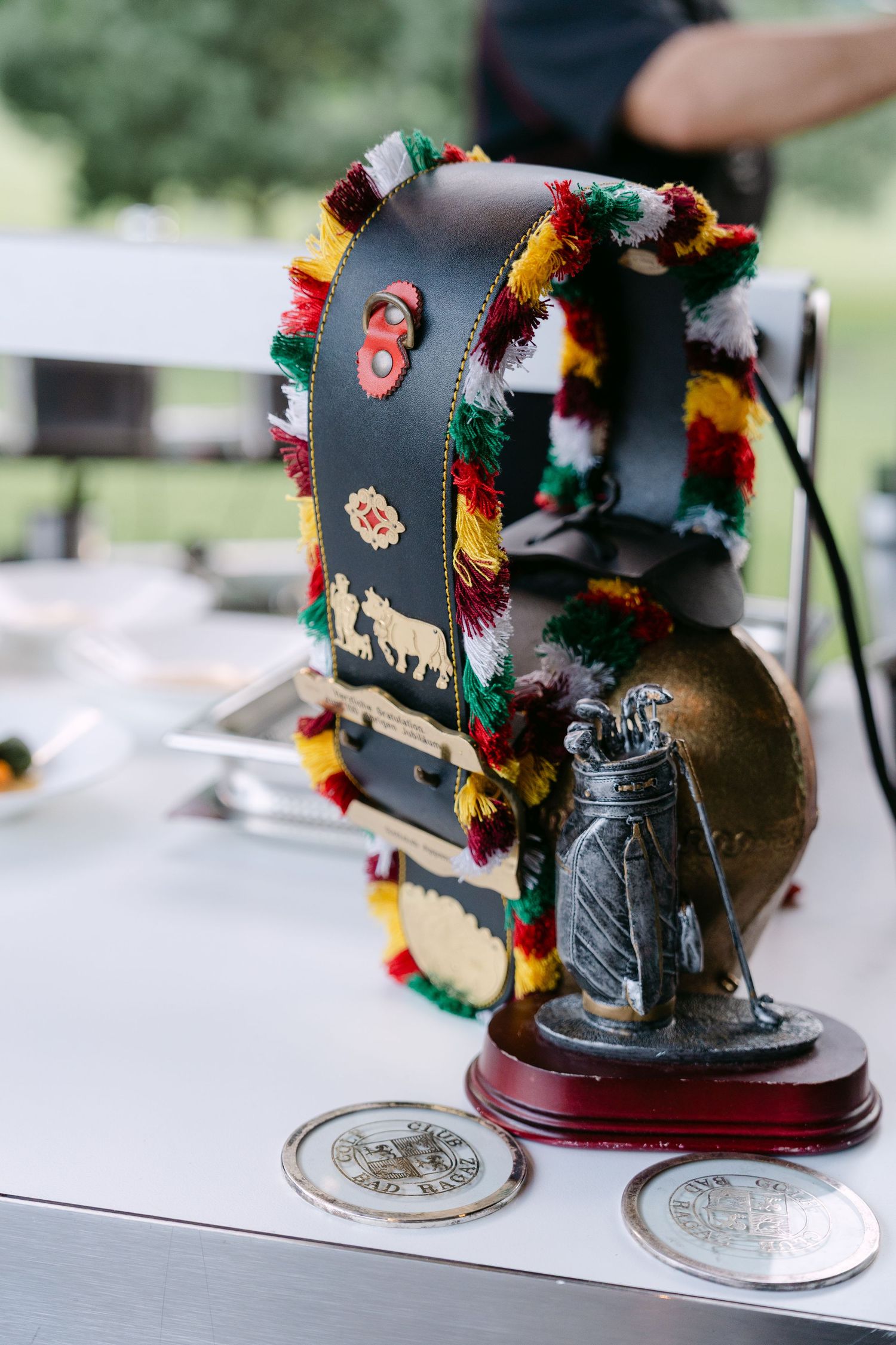 Decorative black bell-shaped objects adorned with colorful tassels on display.