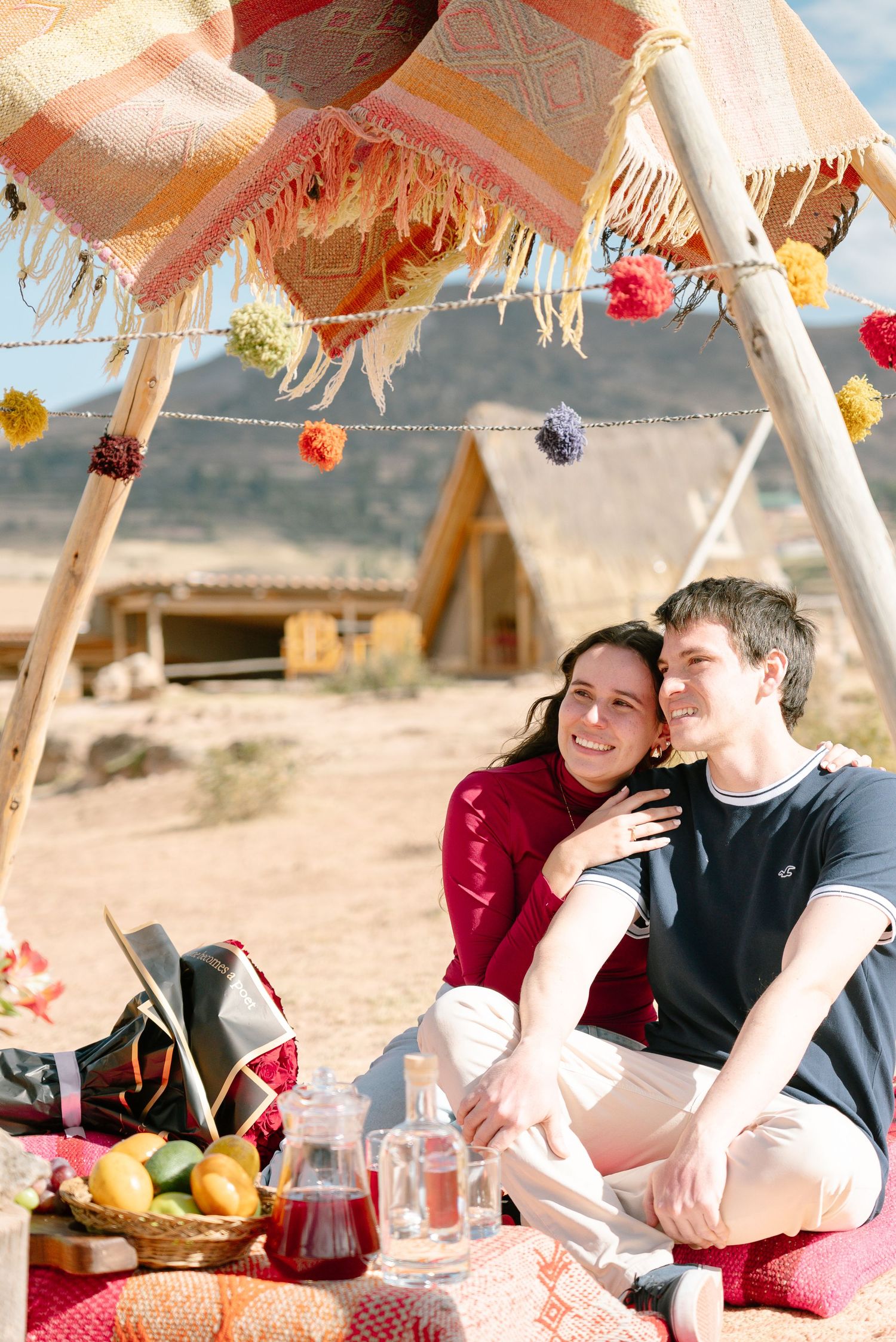 Romantic desert picnic with hanging decorations and fresh fruit spread.