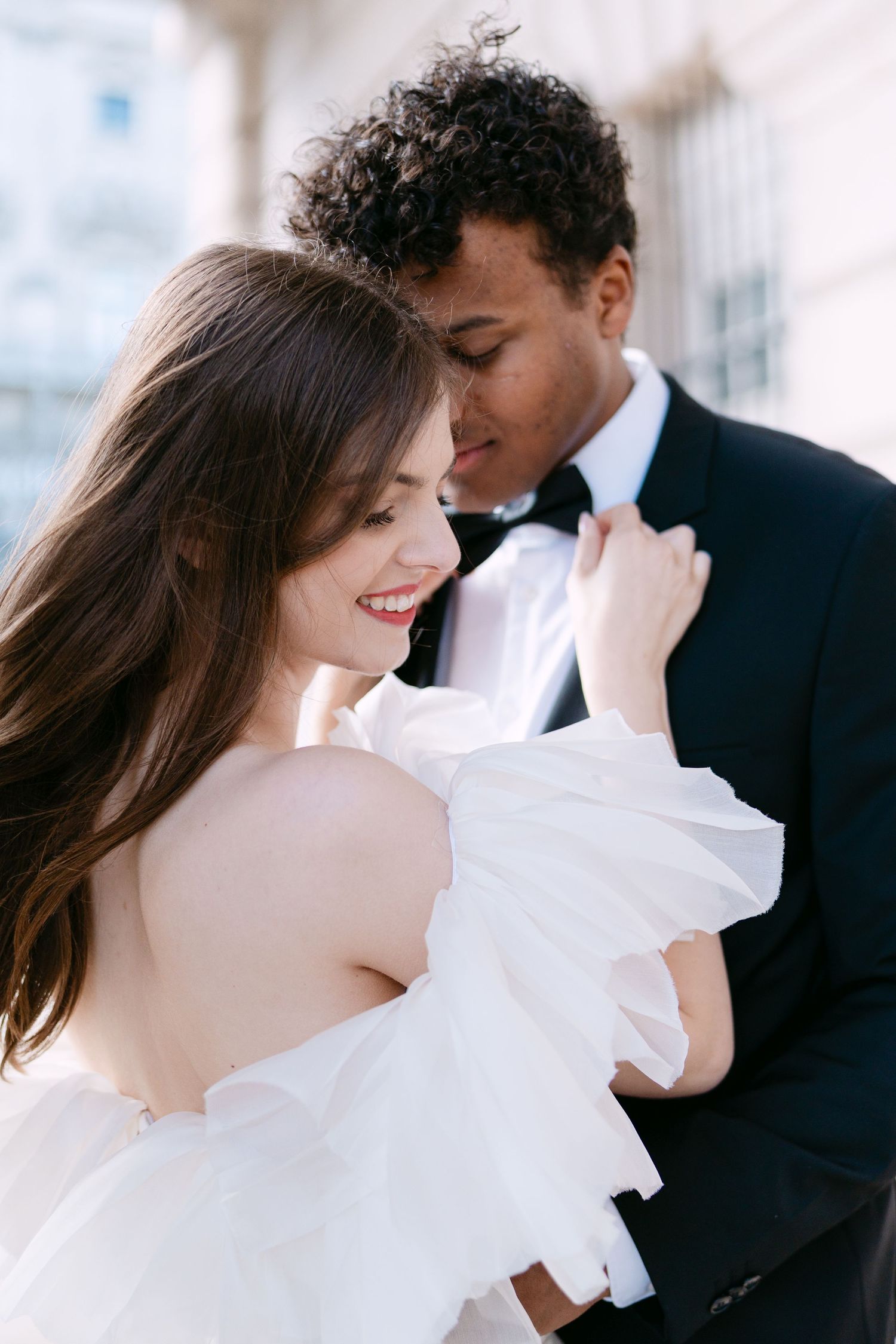 Romantic wedding portrait captured in soft light with flowing white dress details.
