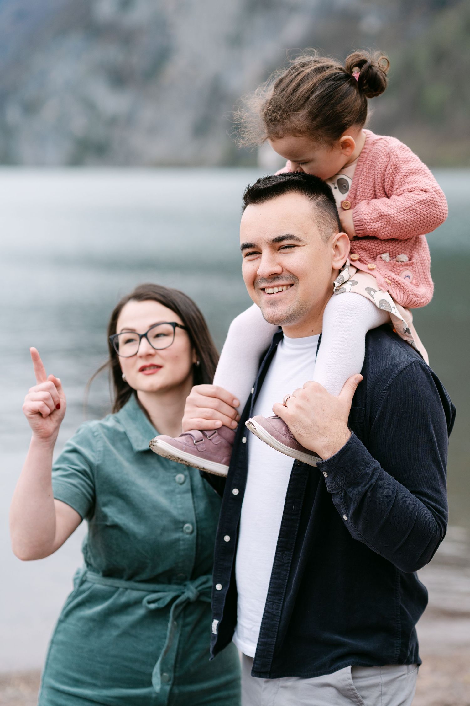 Family sharing playful moments together by a scenic mountain backdrop.