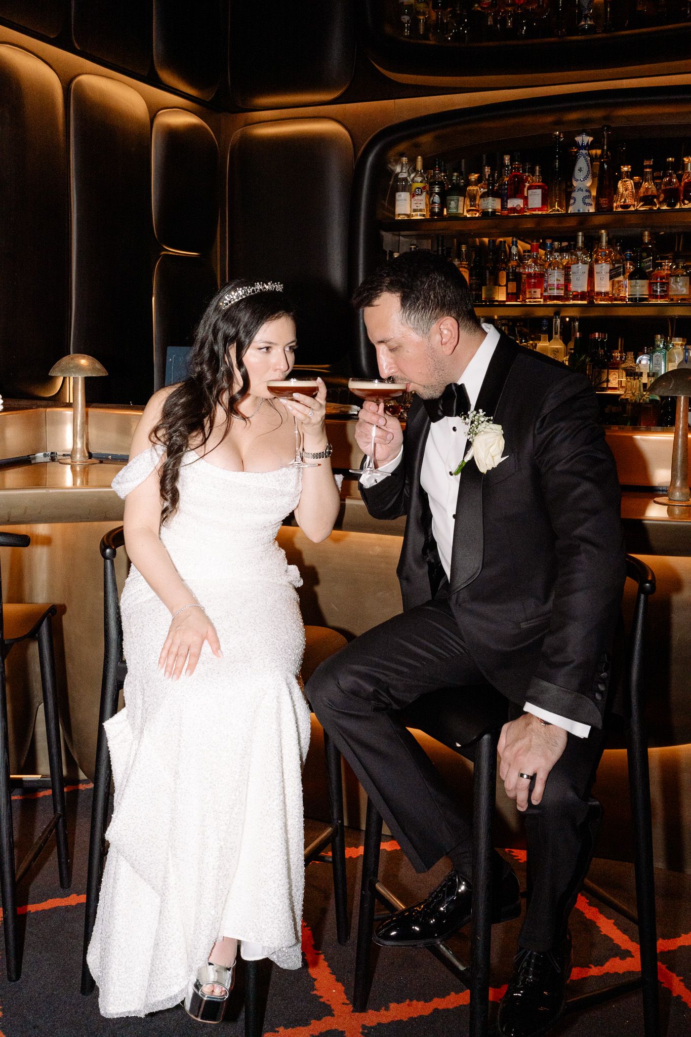 Romantic couple in formal attire share intimate dance poses at dimly lit bar venue.