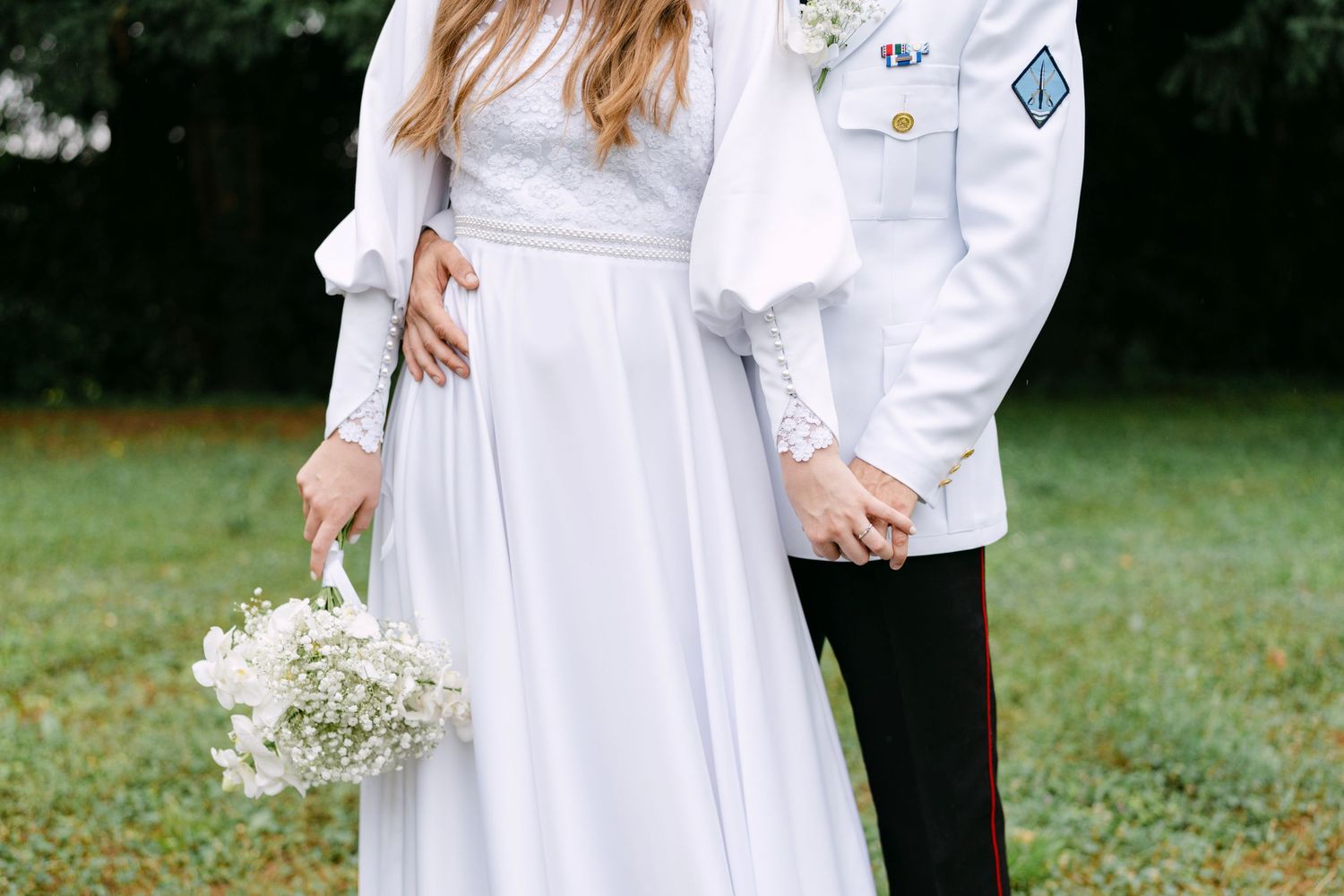 A romantic outdoor wedding scene with white attire and delicate baby's breath flowers.