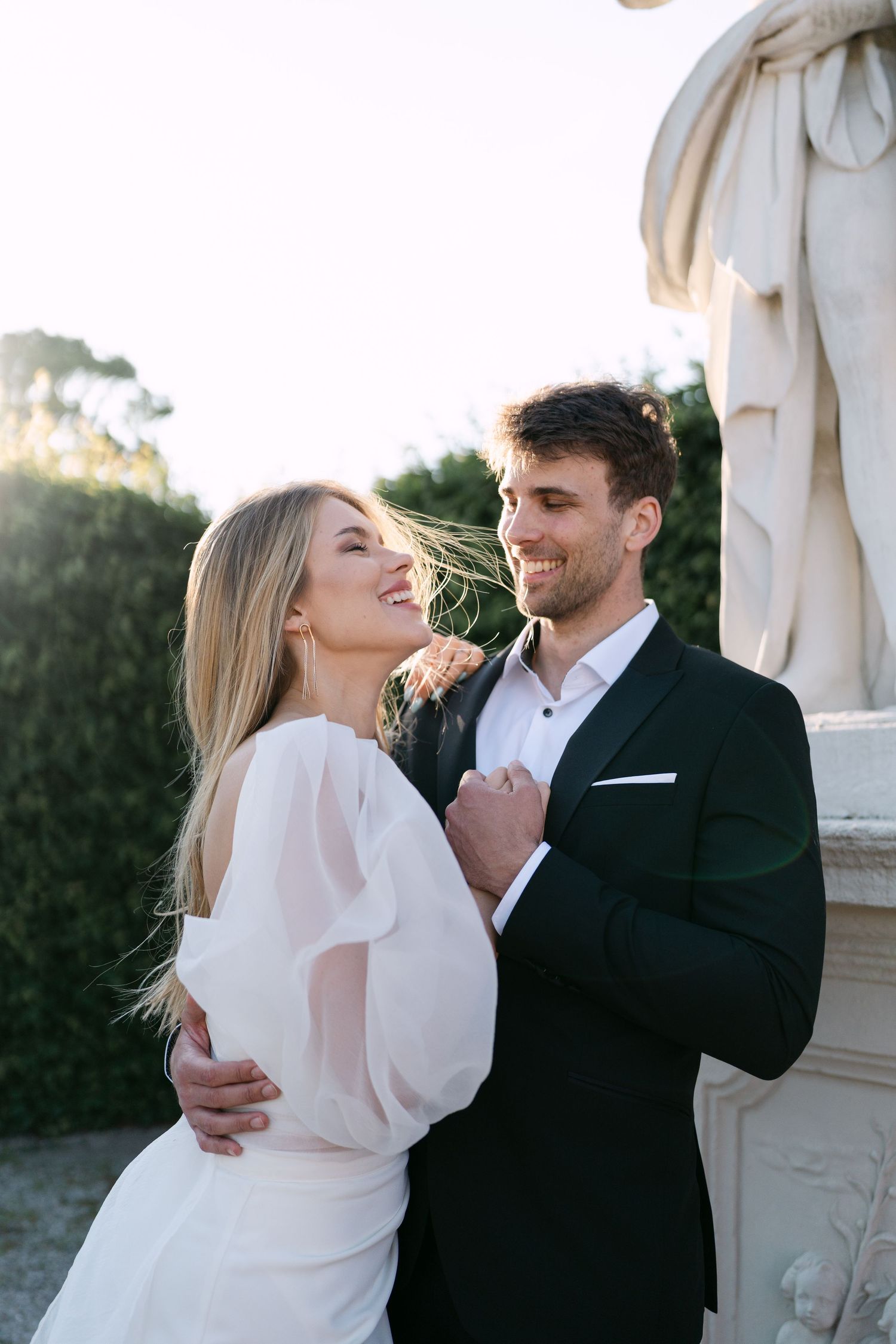 Romantic moment captured at sunset against classic architectural backdrop.