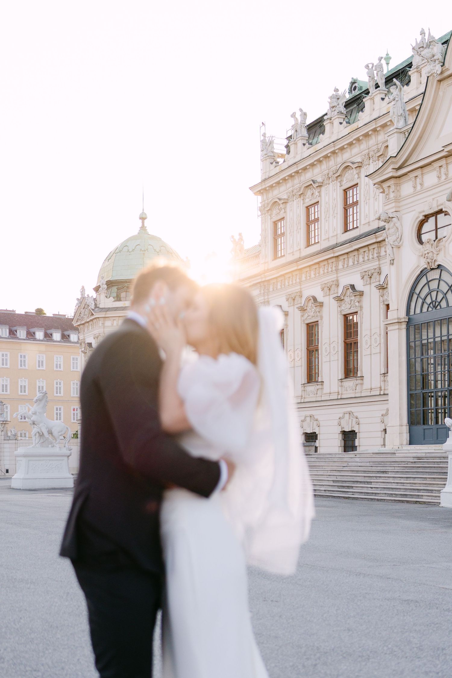 Intimate wedding portraits with dramatic architecture and sunset lighting.