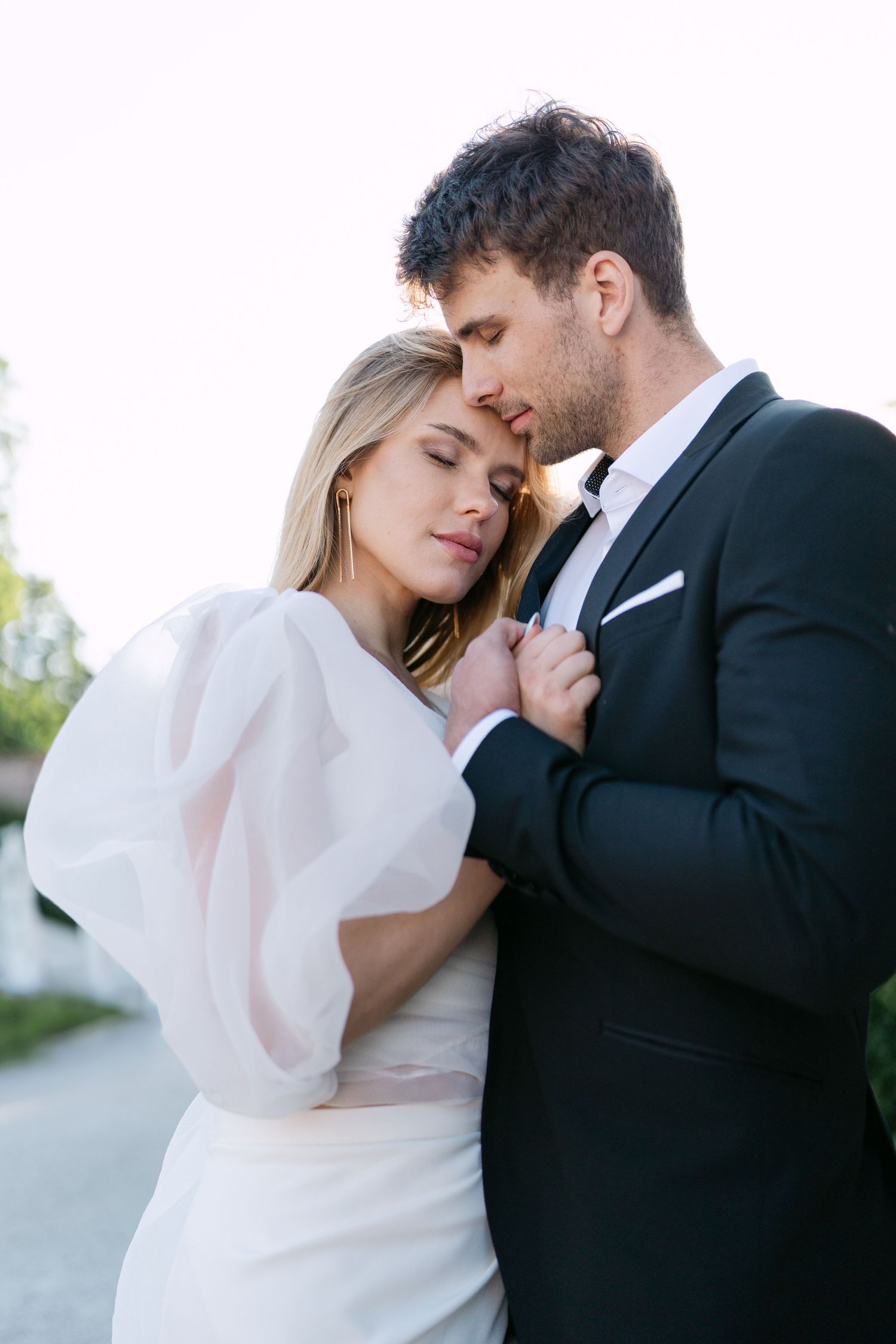 An intimate wedding portrait showing a tender moment between newlyweds in formal attire.