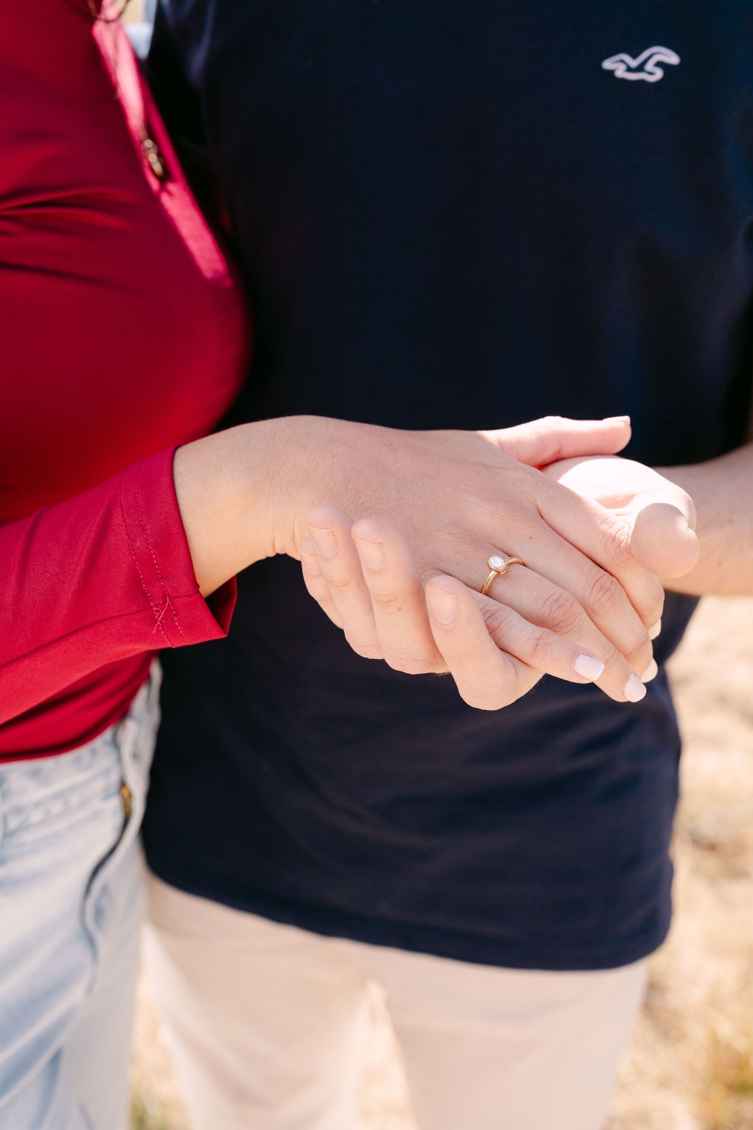 Close-up shots of hands touching and embracing in an outdoor setting.